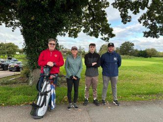 A group of people standing next to each other on a golf course.