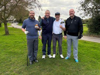 A group of men are posing for a picture on a golf course.