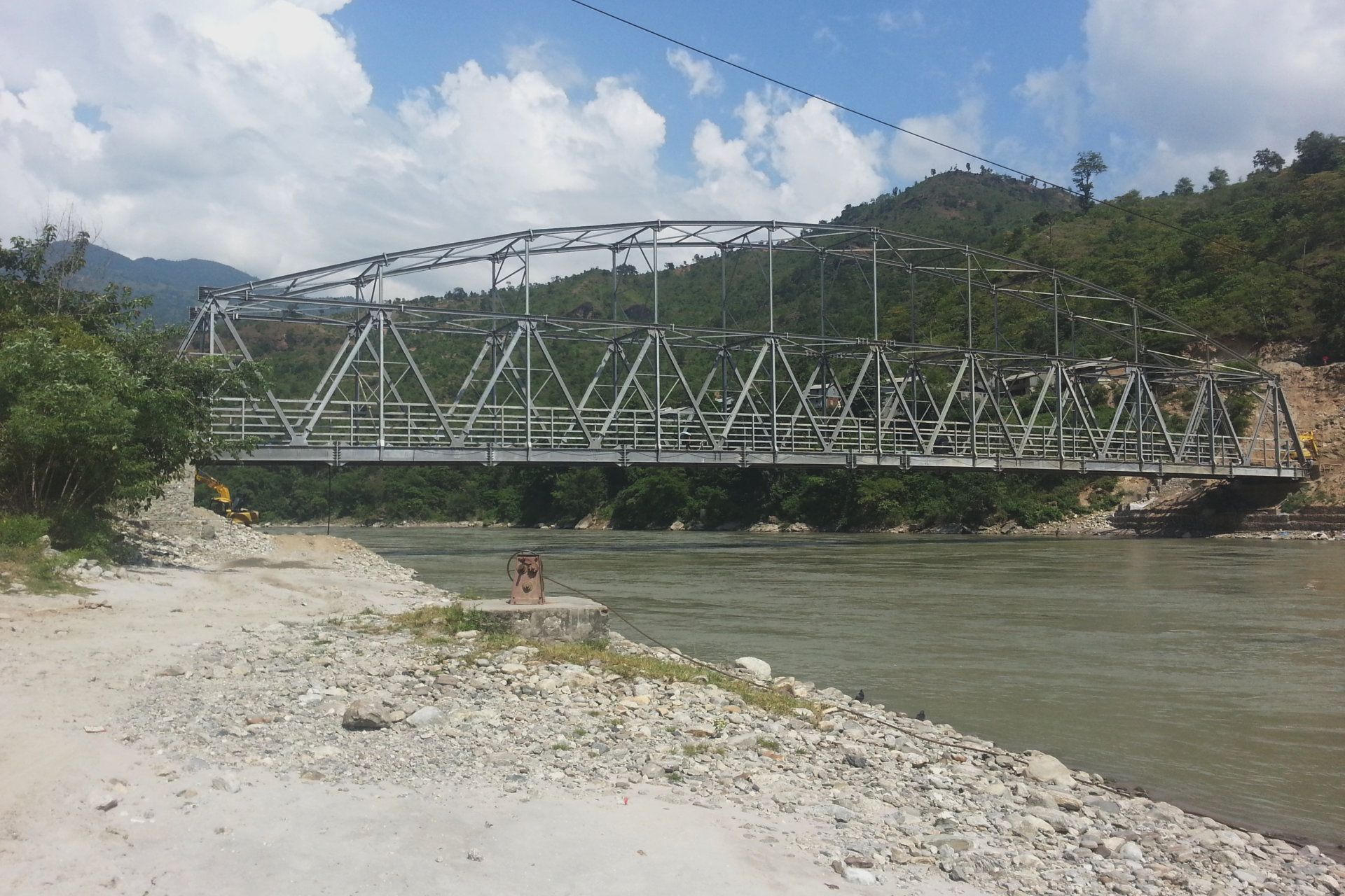 A bridge over a river with mountains in the background