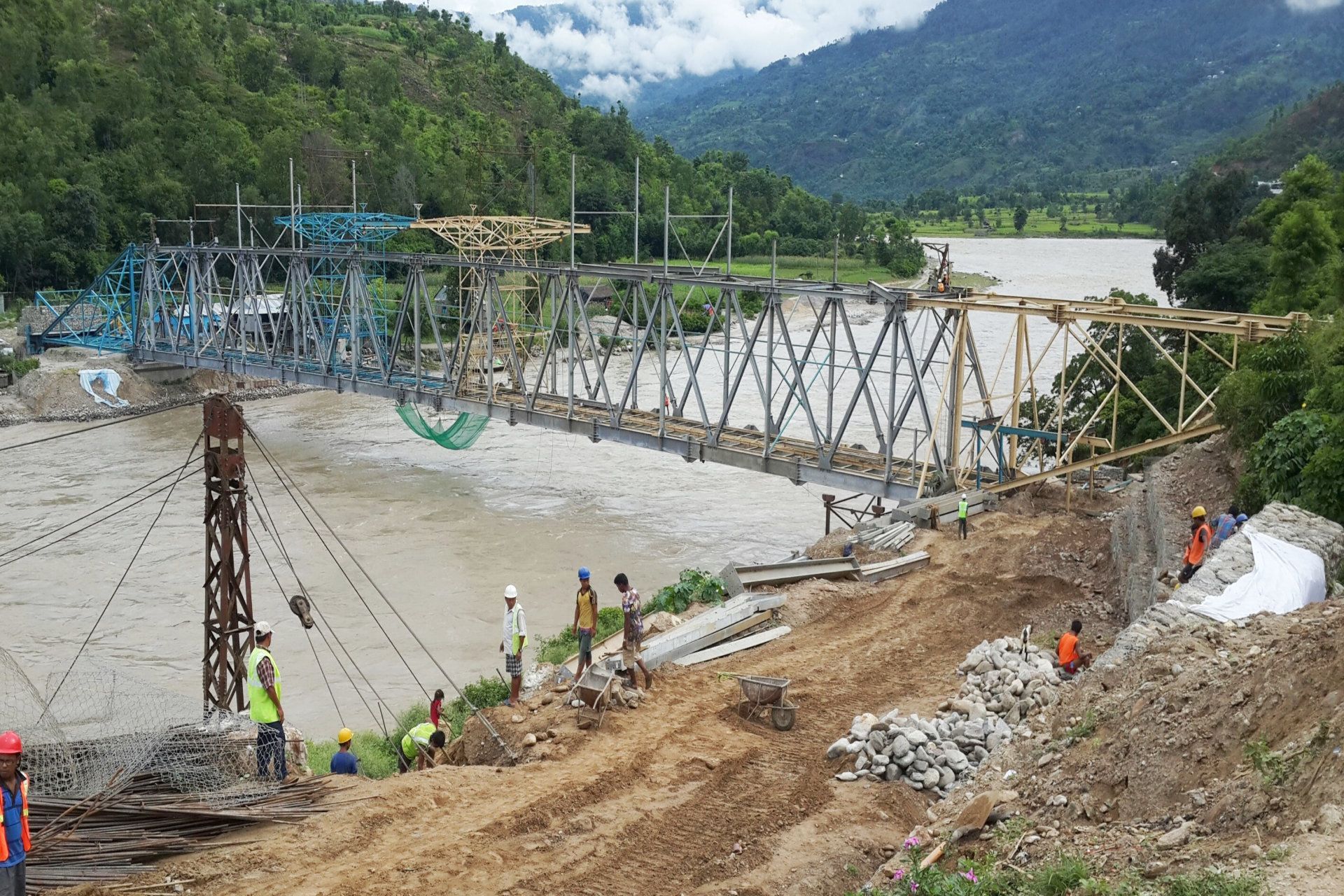 A bridge is being built over a river in the mountains.