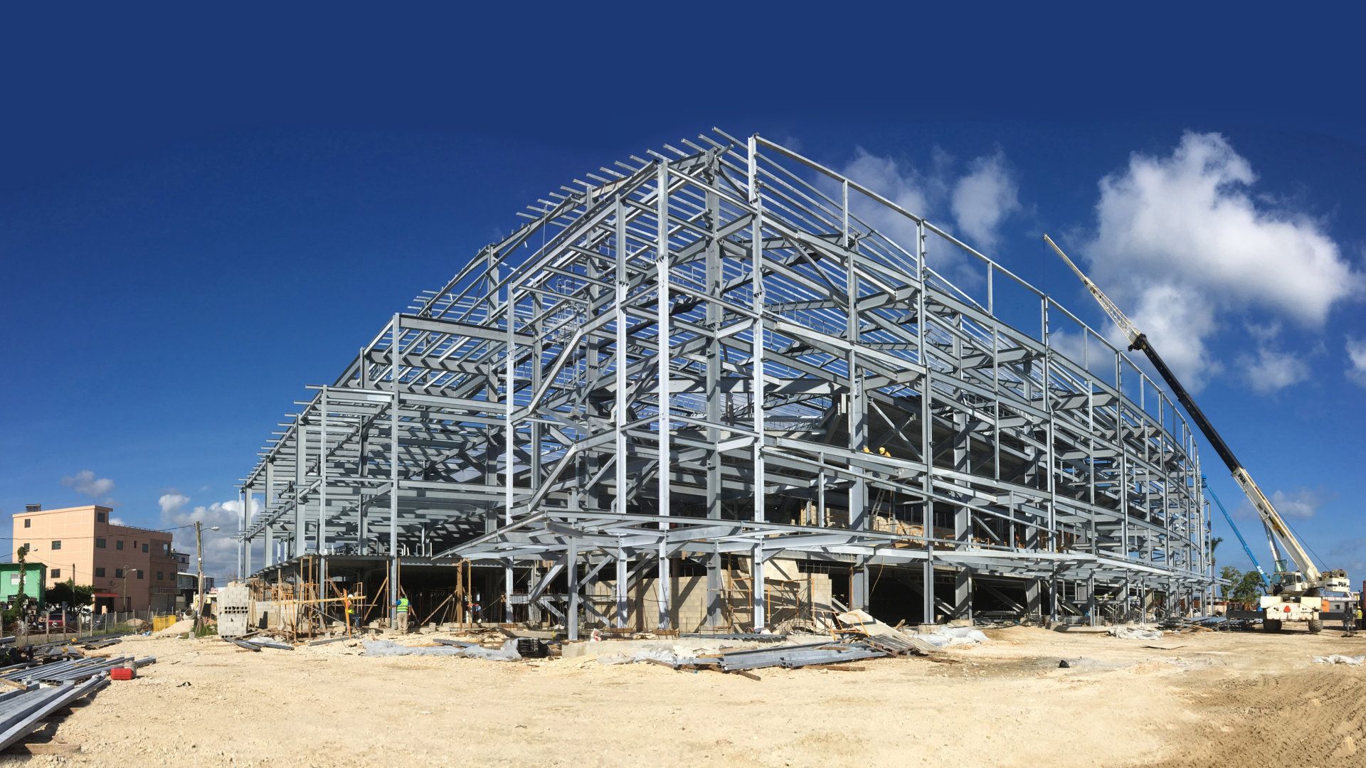 A large building under construction with a crane in the foreground.