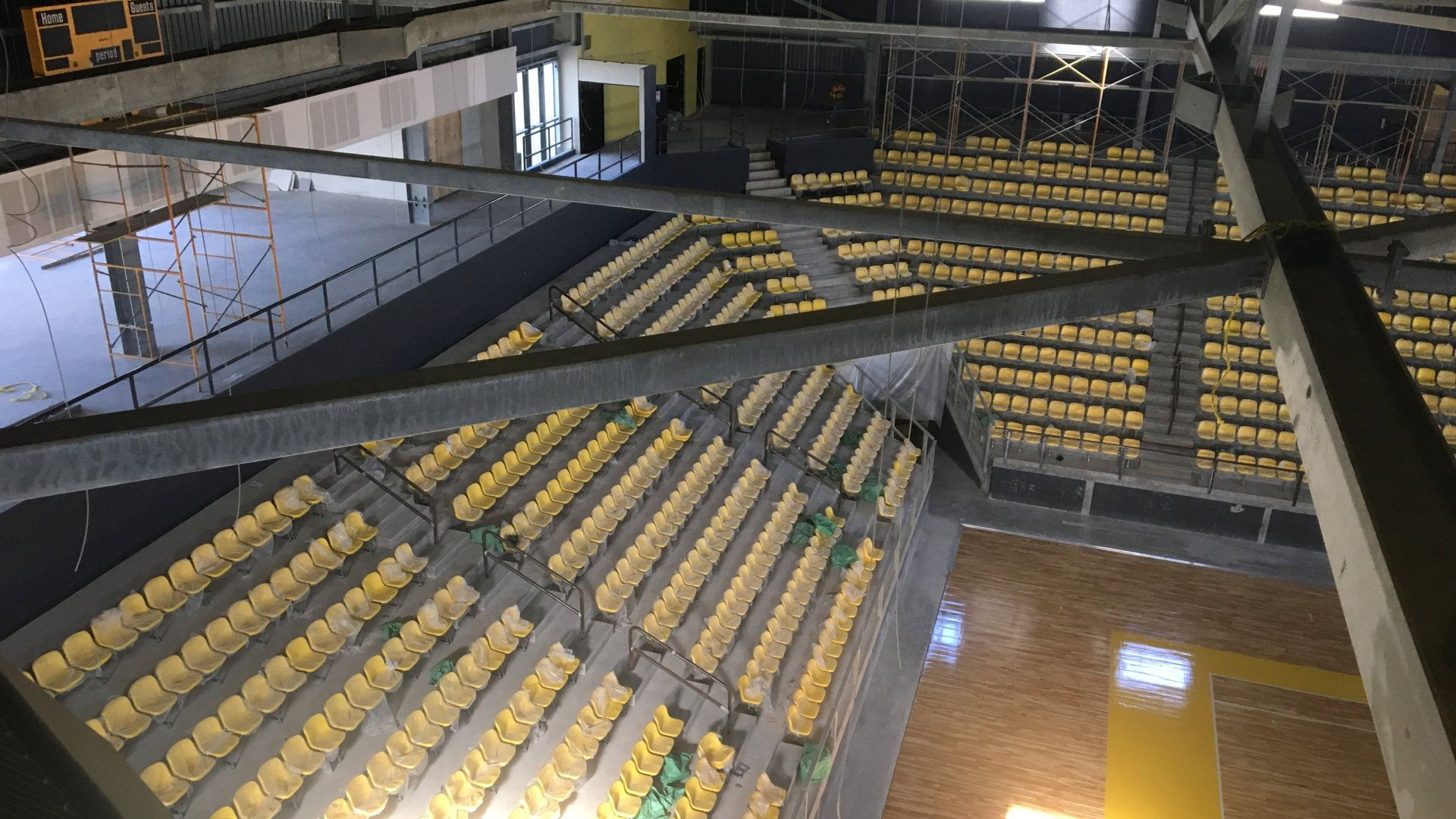 An aerial view of a stadium with rows of yellow seats.