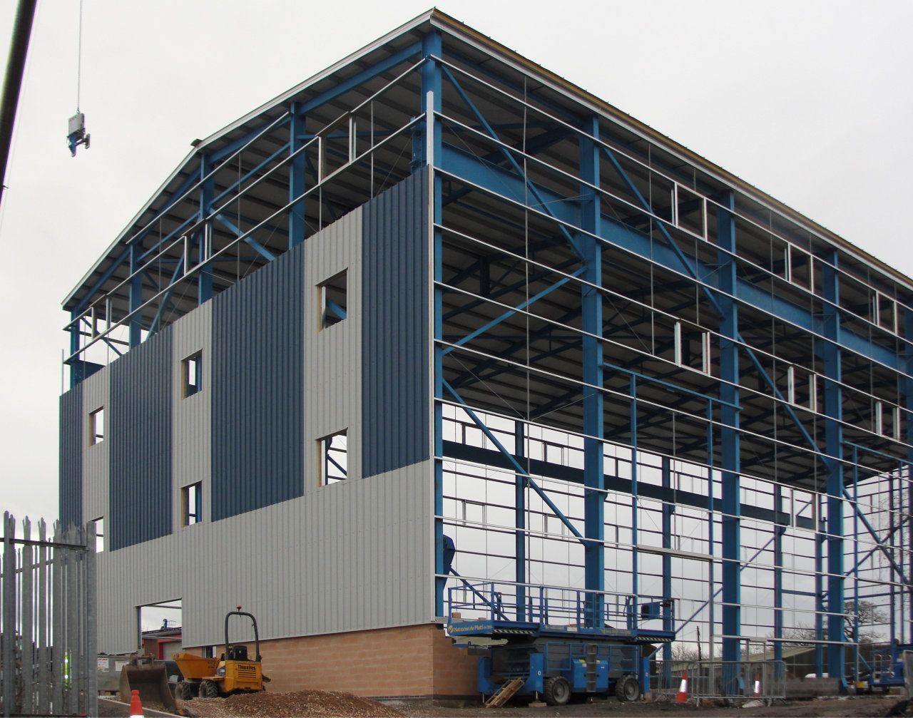 A large building under construction with a crane in the background