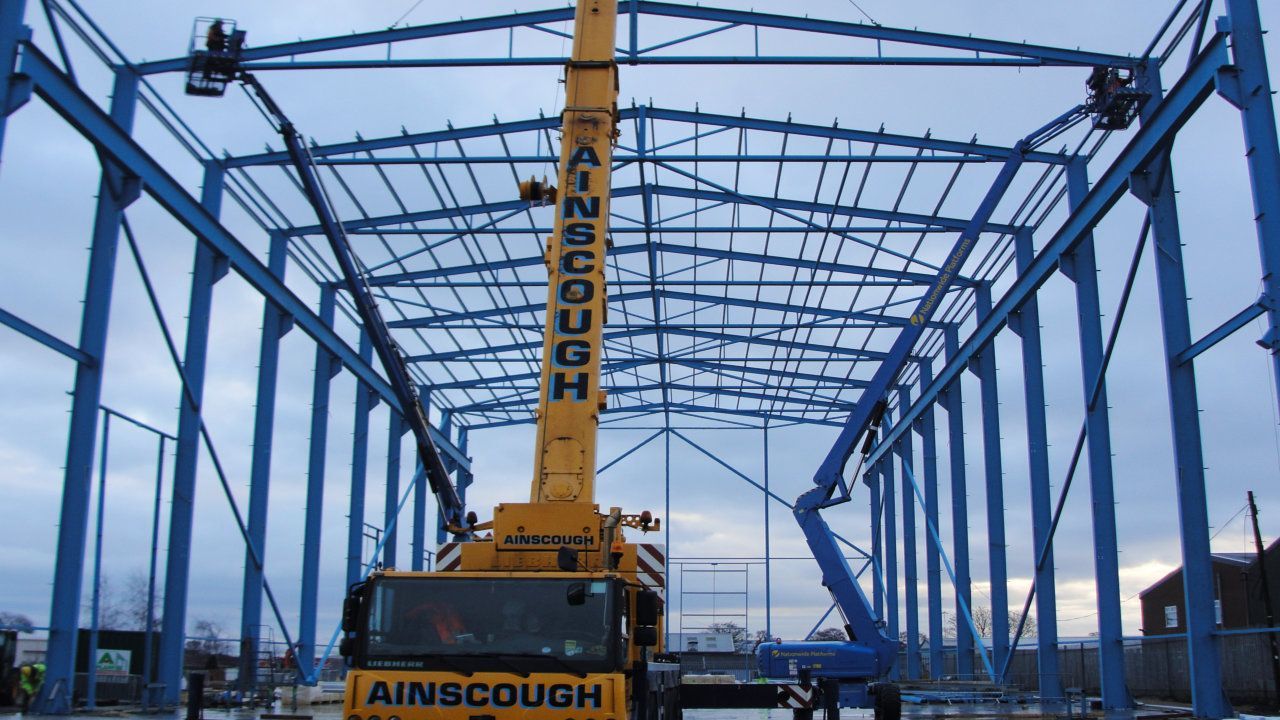 A yellow crane with the word ainscough on it