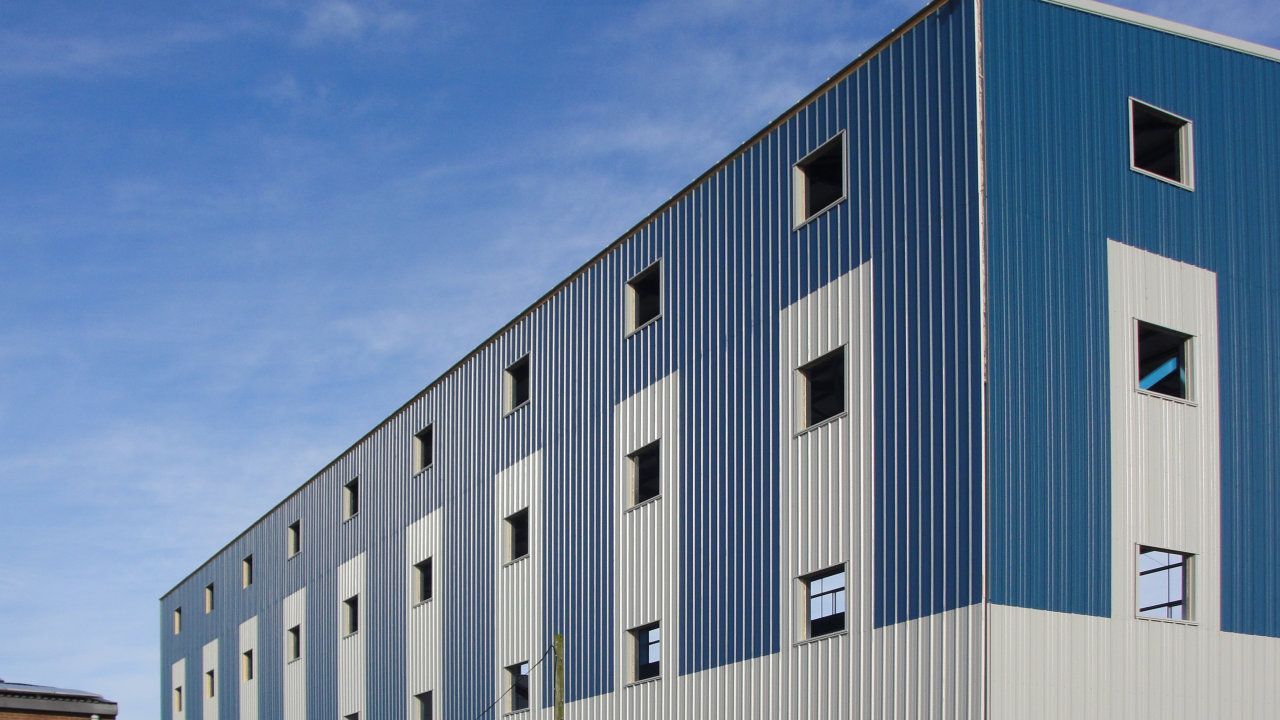 A large blue and white building with a blue sky in the background.