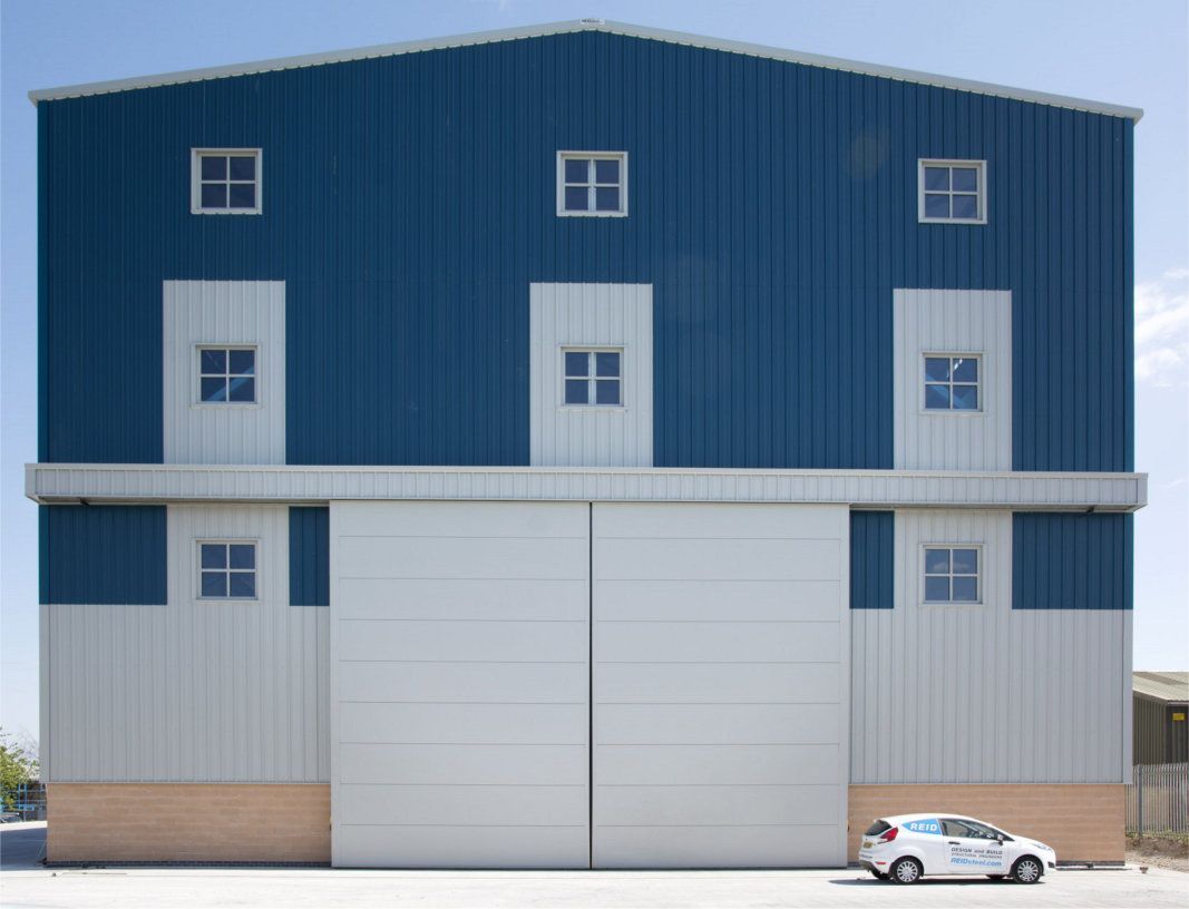 A blue and white building with a white van parked in front of it