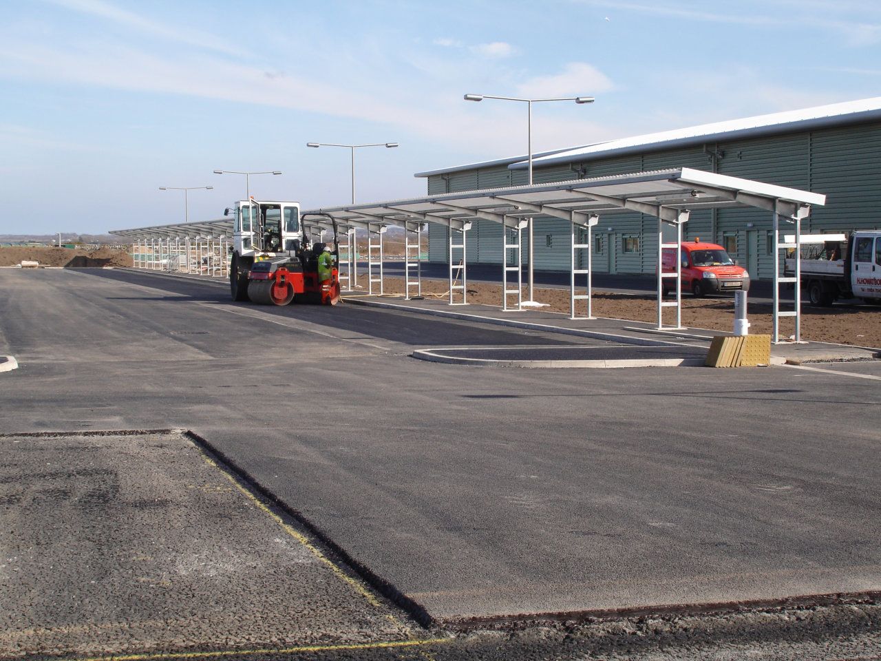 A red forklift is parked on the side of the road