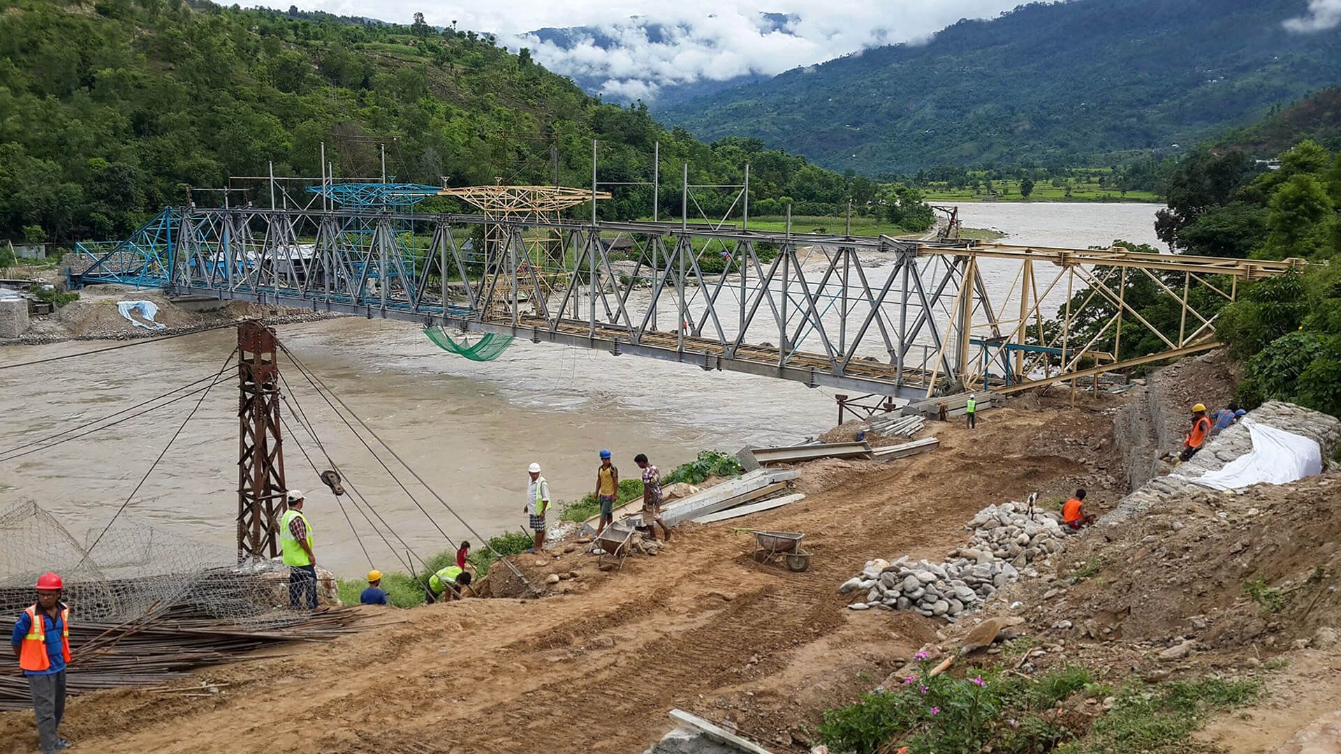 A bridge is being built over a river in the mountains.