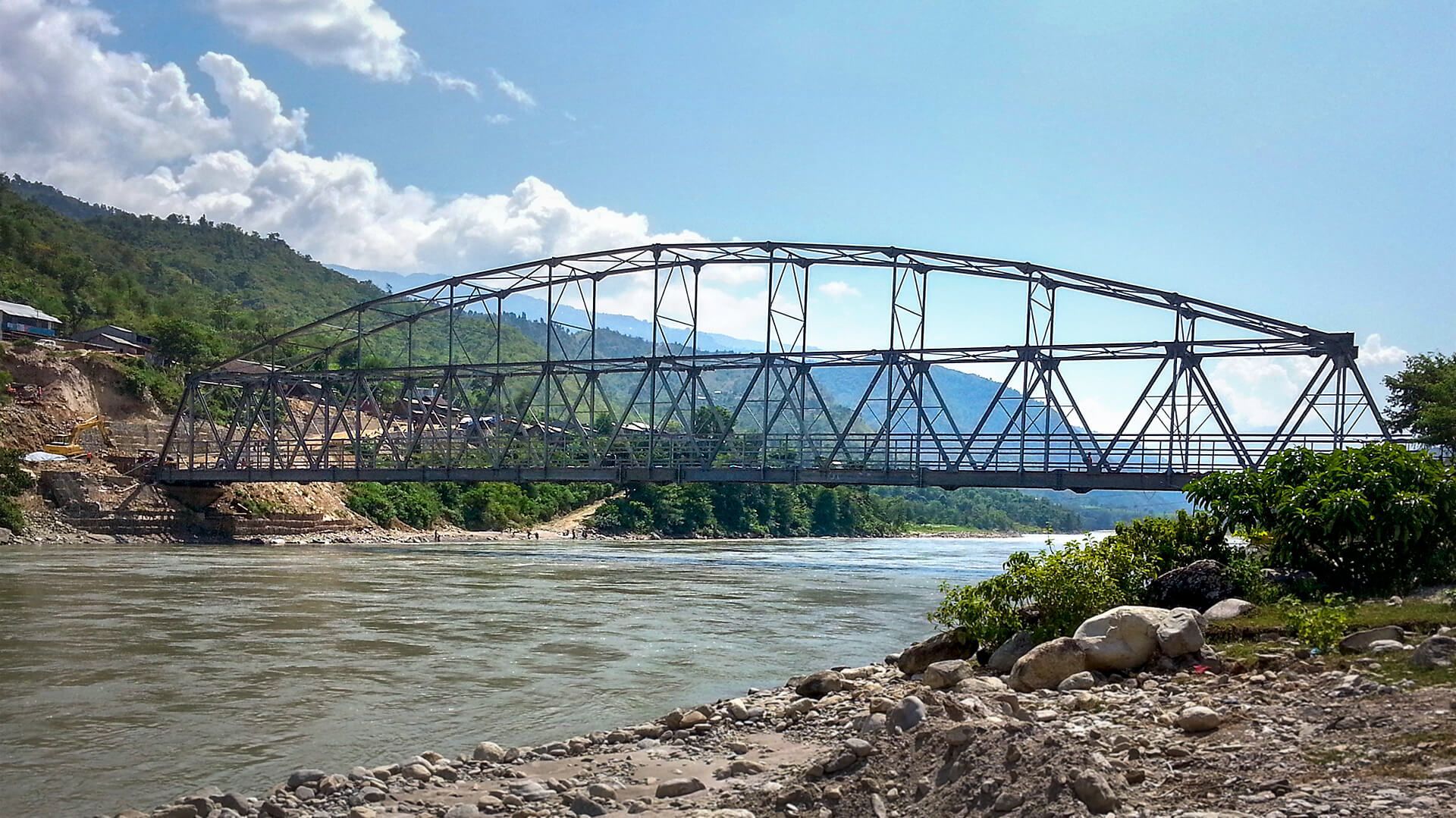 A bridge over a river with mountains in the background