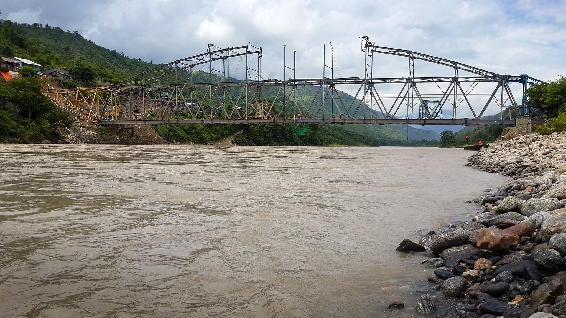 A bridge over a river with mountains in the background