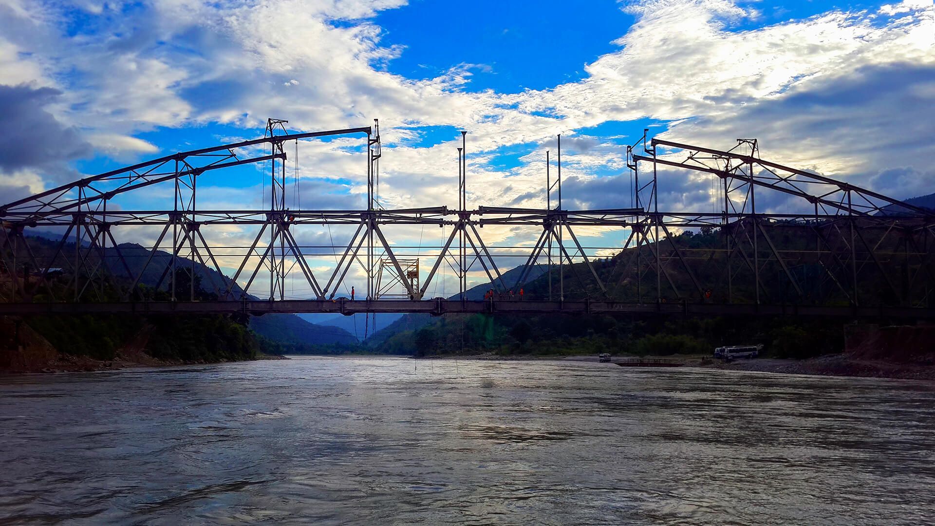 A bridge over a river with mountains in the background