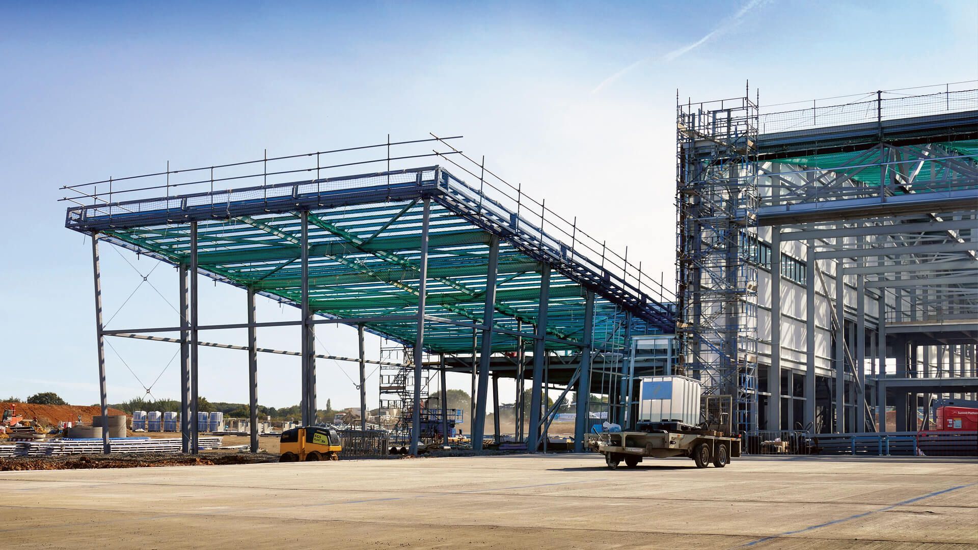 A large building under construction with a truck parked in front of it