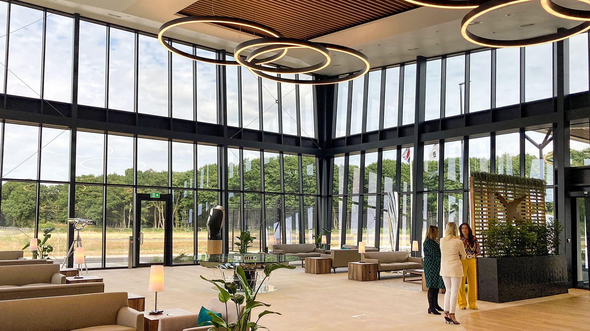 A large room with a lot of windows and people standing in it.