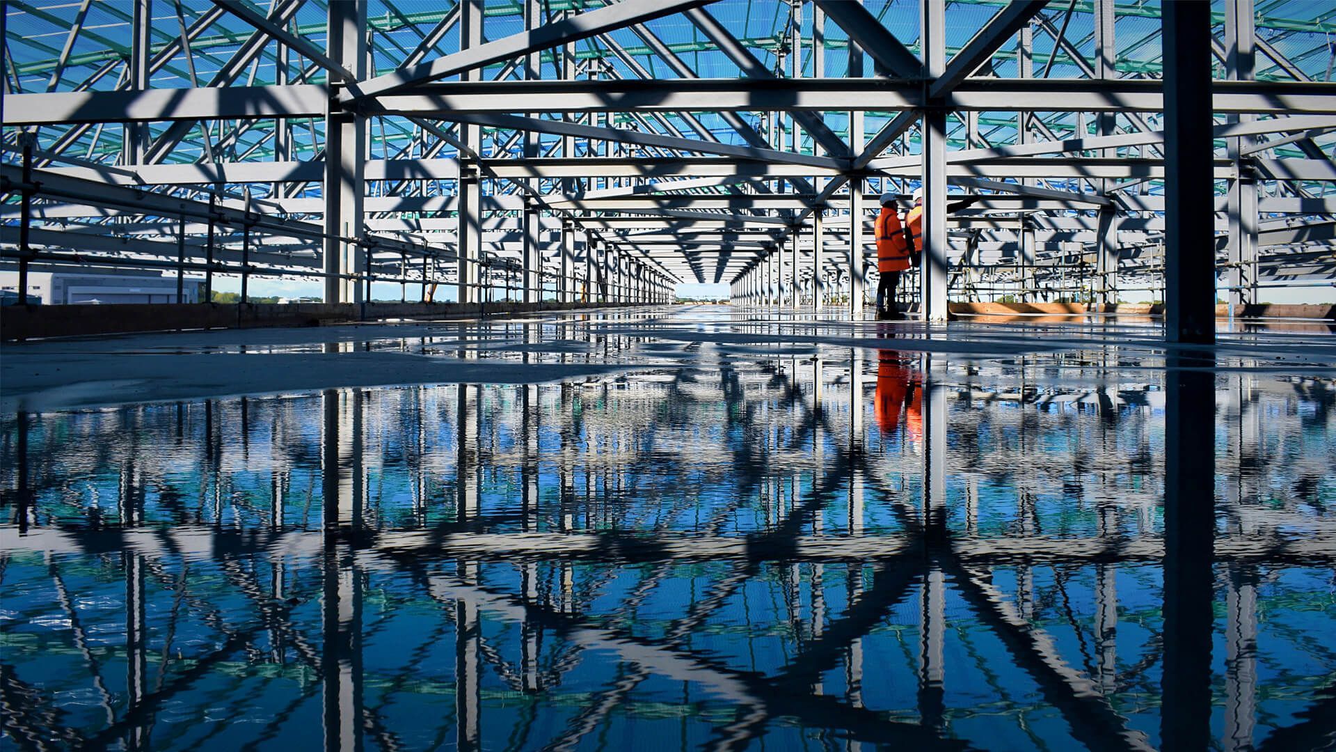 A man and a woman are walking through a building under construction.