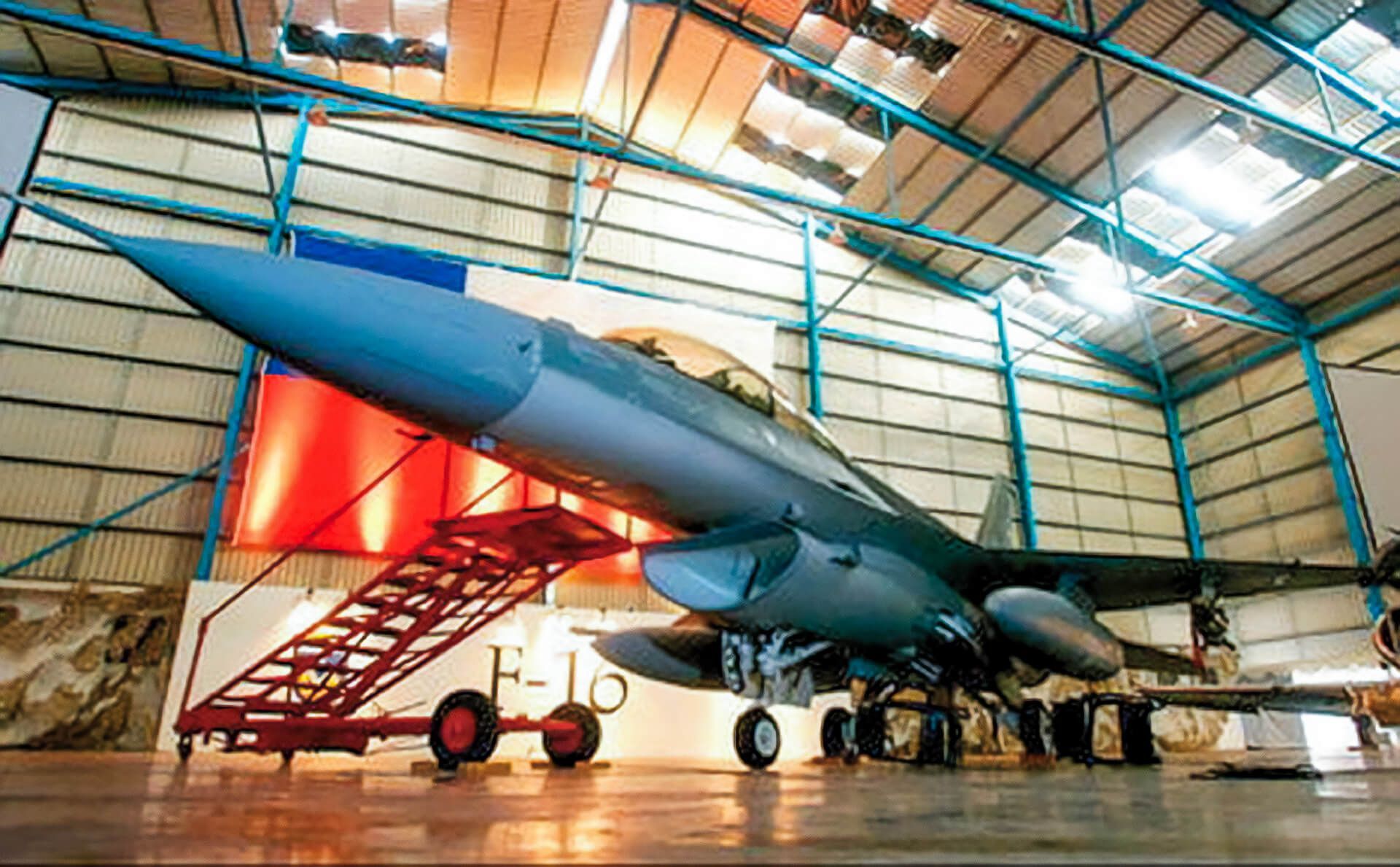 A large fighter jet is parked in a hangar.
