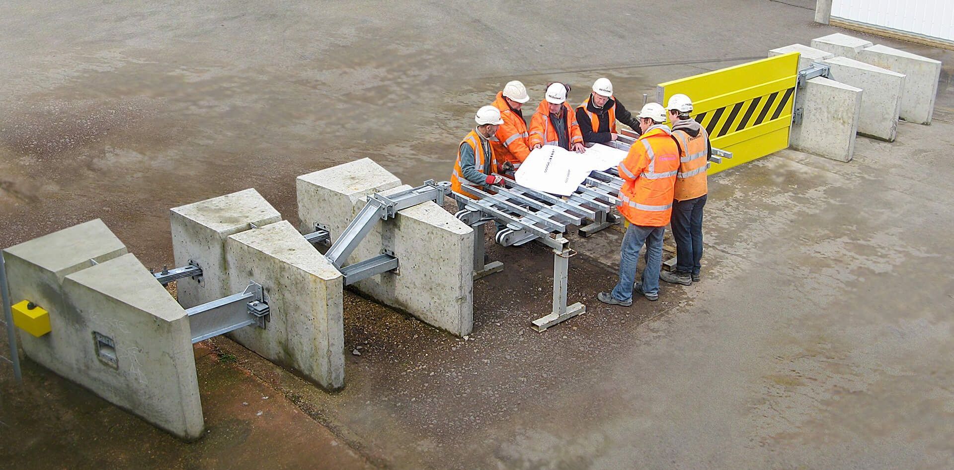 A group of construction workers are standing around a table.