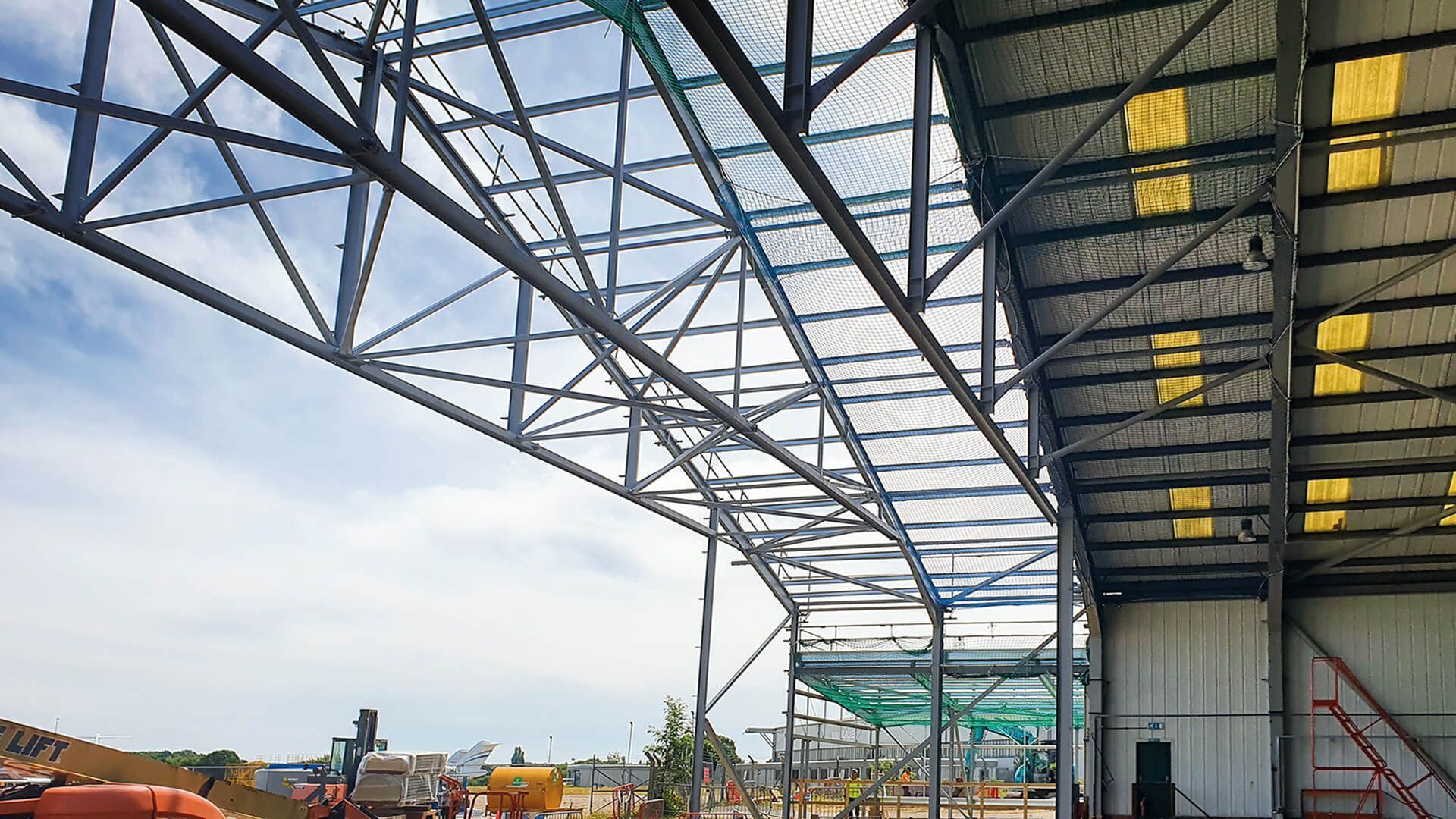 A large metal structure is being built on top of a building.