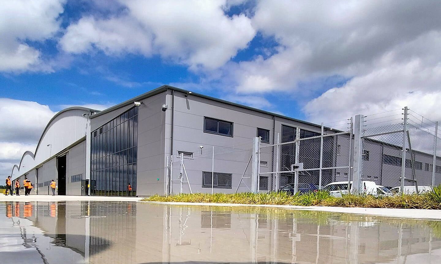 A large building is reflected in a puddle of water.
