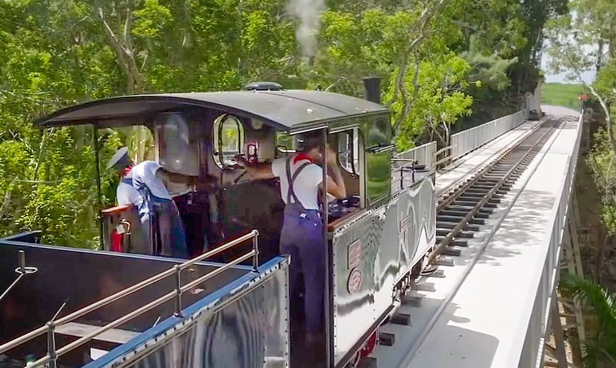 A train is going down a hill on a bridge.