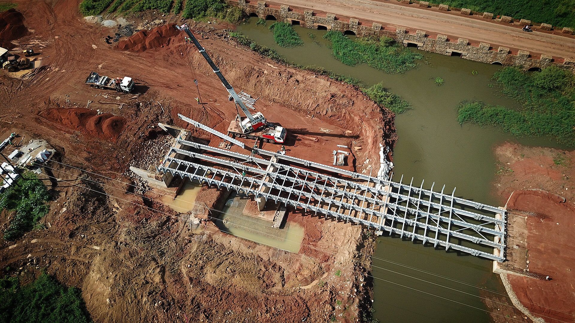 An aerial view of a bridge being built over a river.