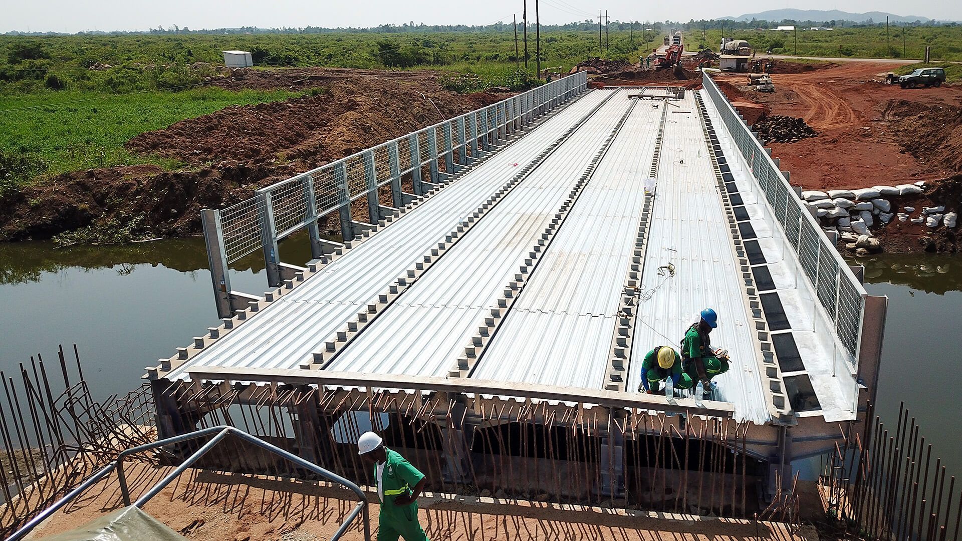 A group of construction workers are working on a bridge over a body of water