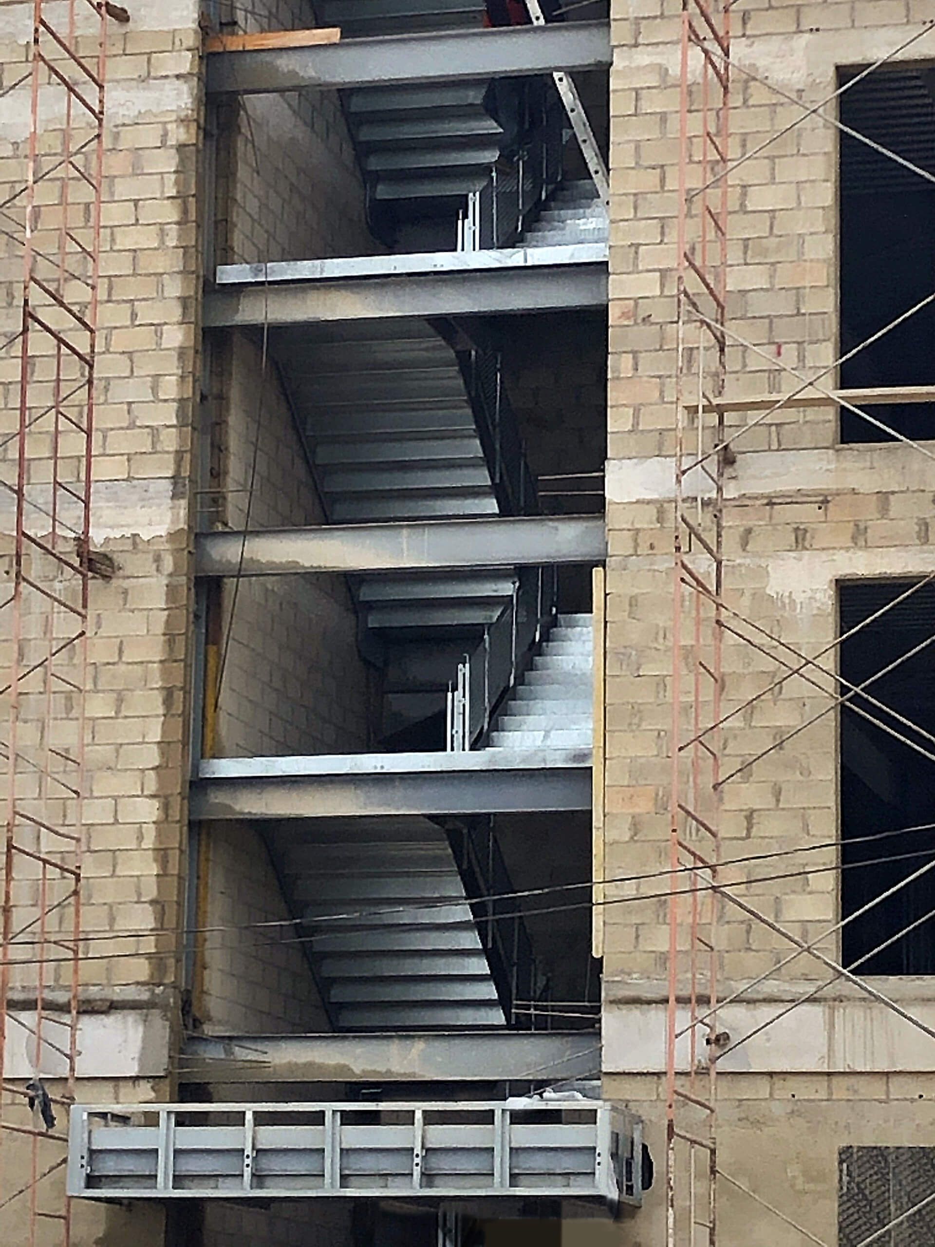 A building under construction with stairs and scaffolding