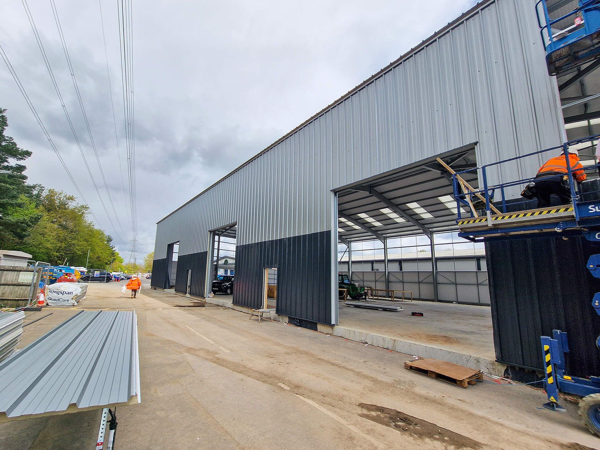 A large building is being built on a dirt road.