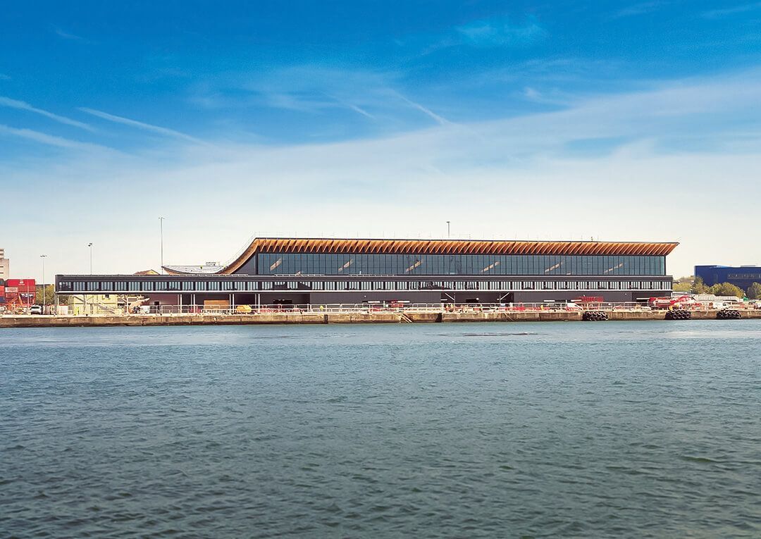 A large building is sitting next to a body of water.