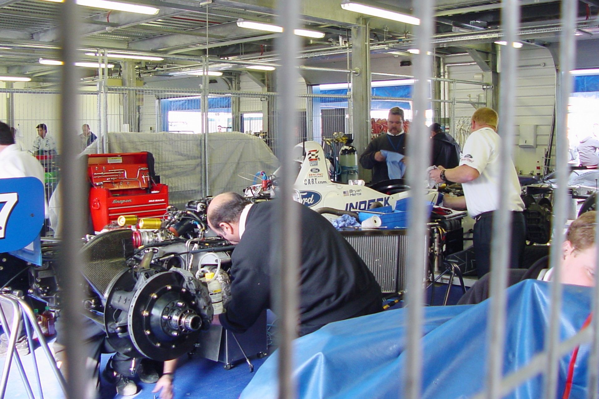 A man is working on a car engine with the number 7 on it