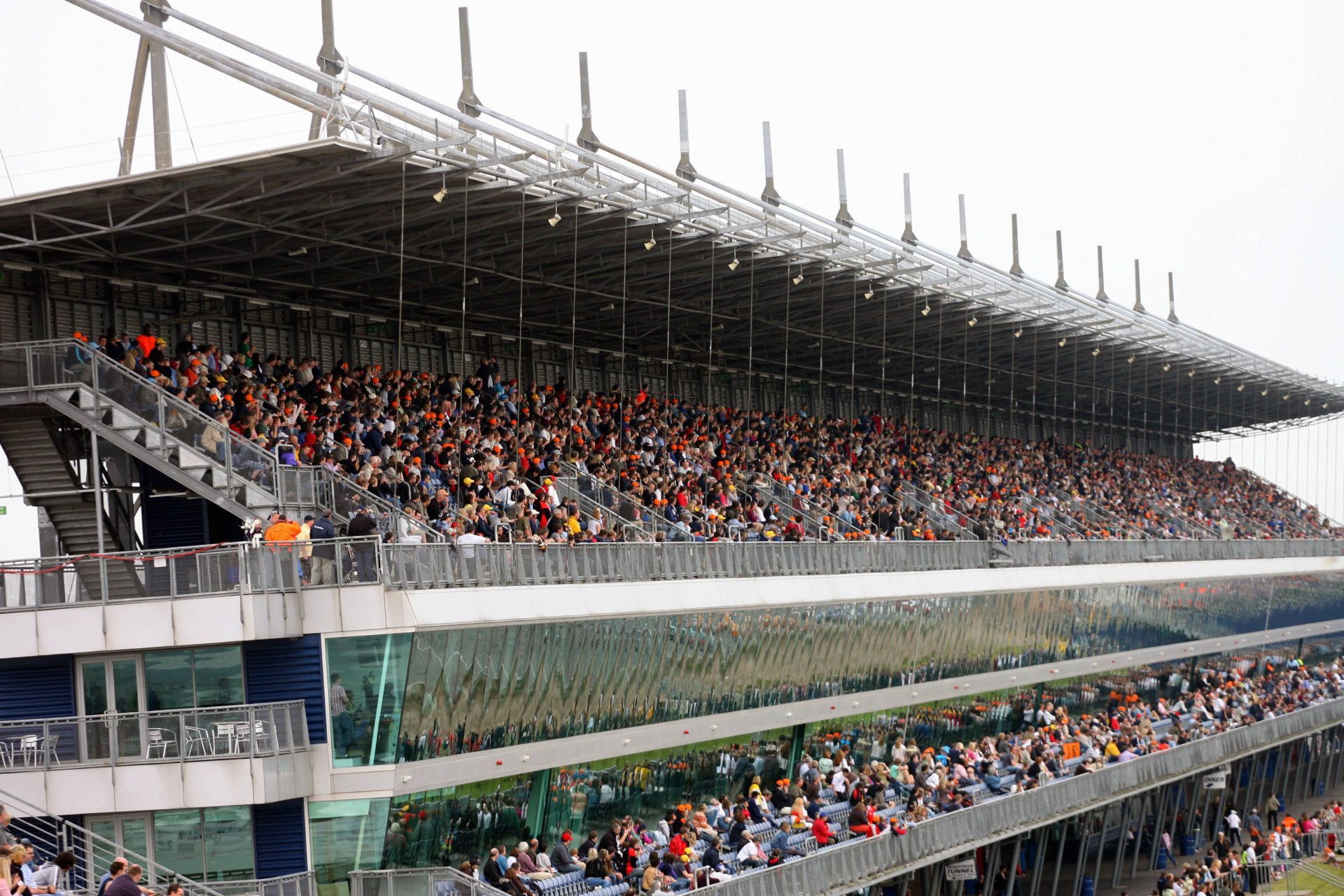 A large crowd of people are sitting in a stadium watching a race.