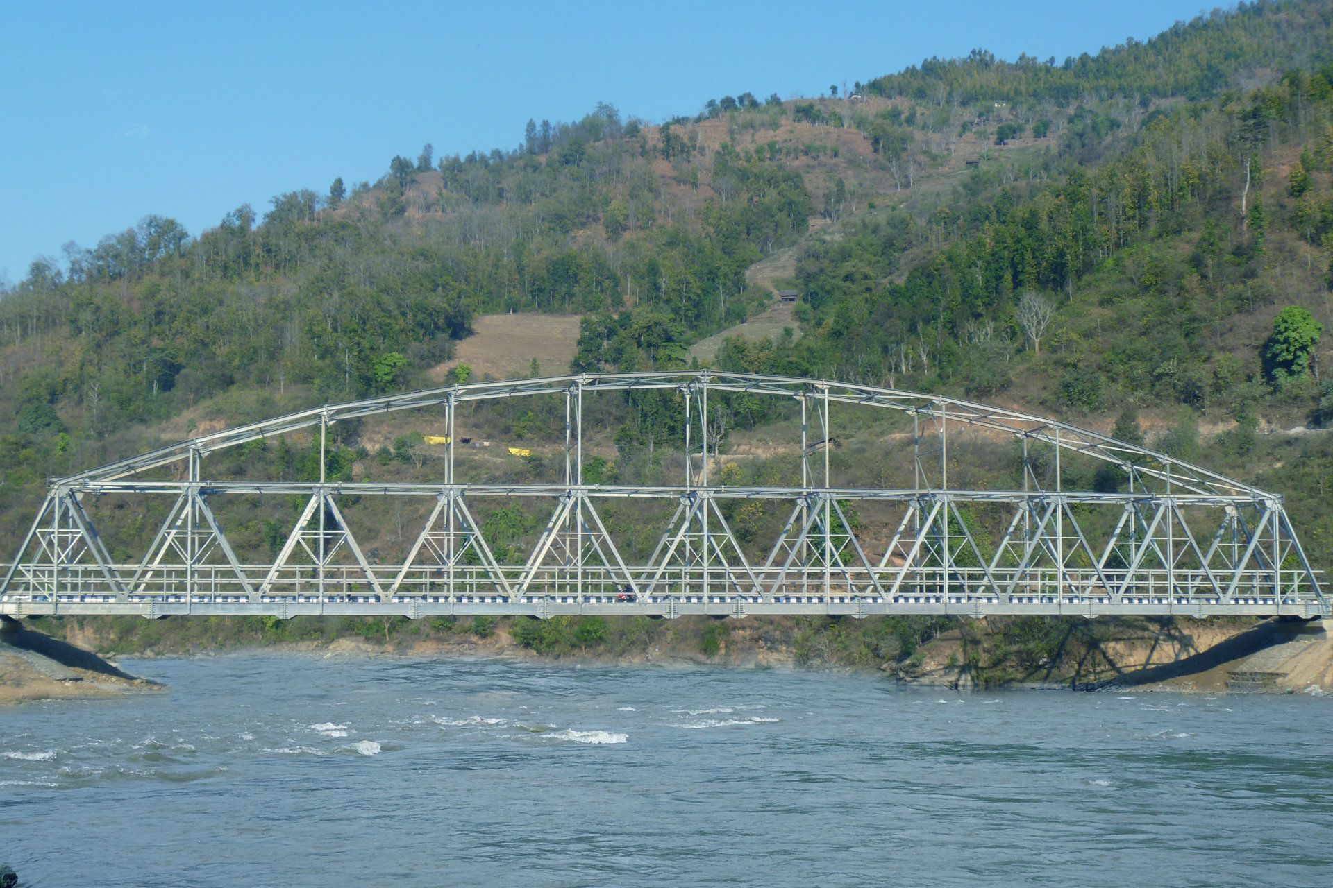 A bridge over a river with mountains in the background