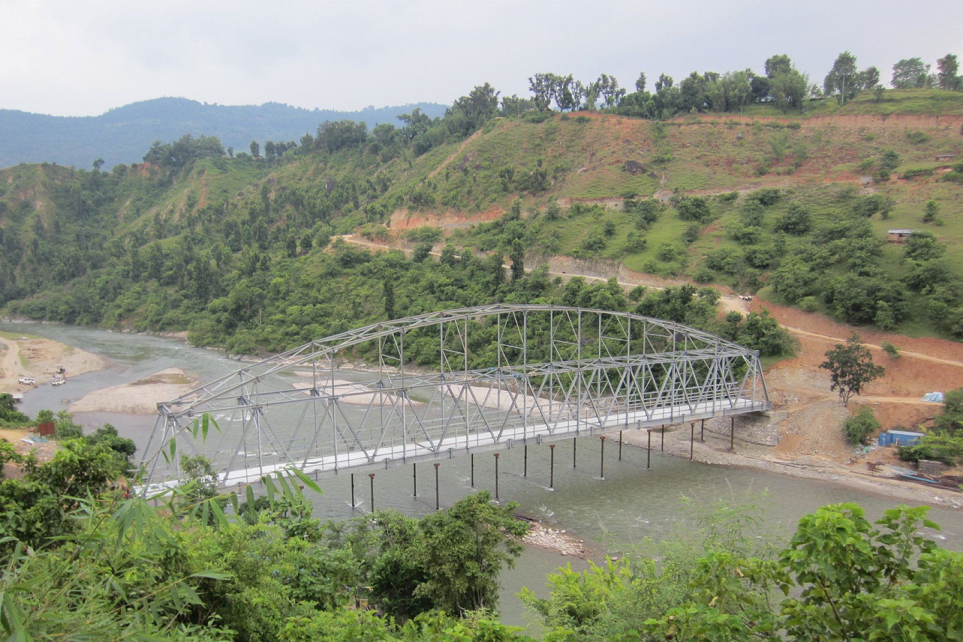 A bridge over a river in the middle of a forest.