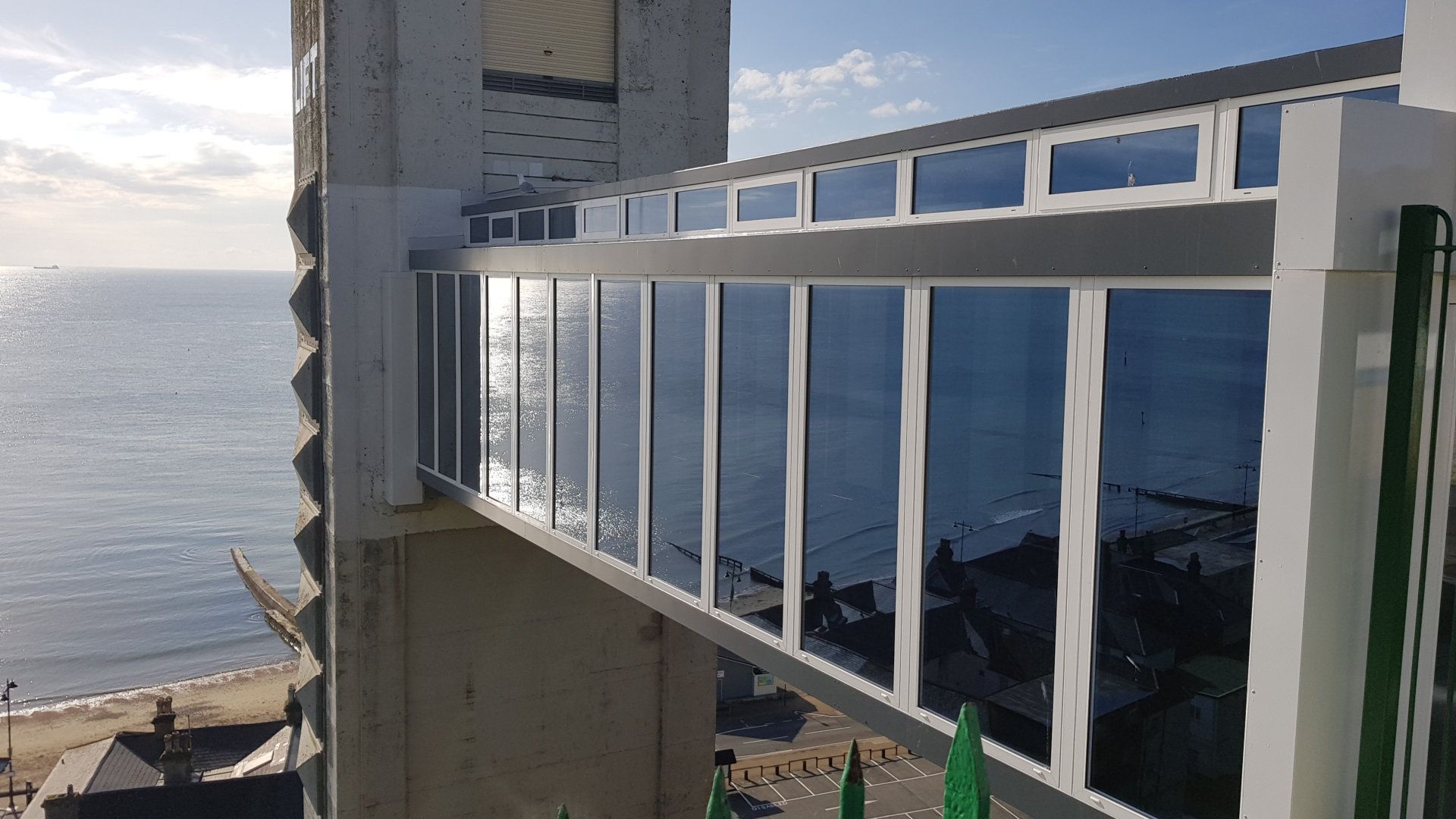 A large building with a balcony overlooking the ocean.