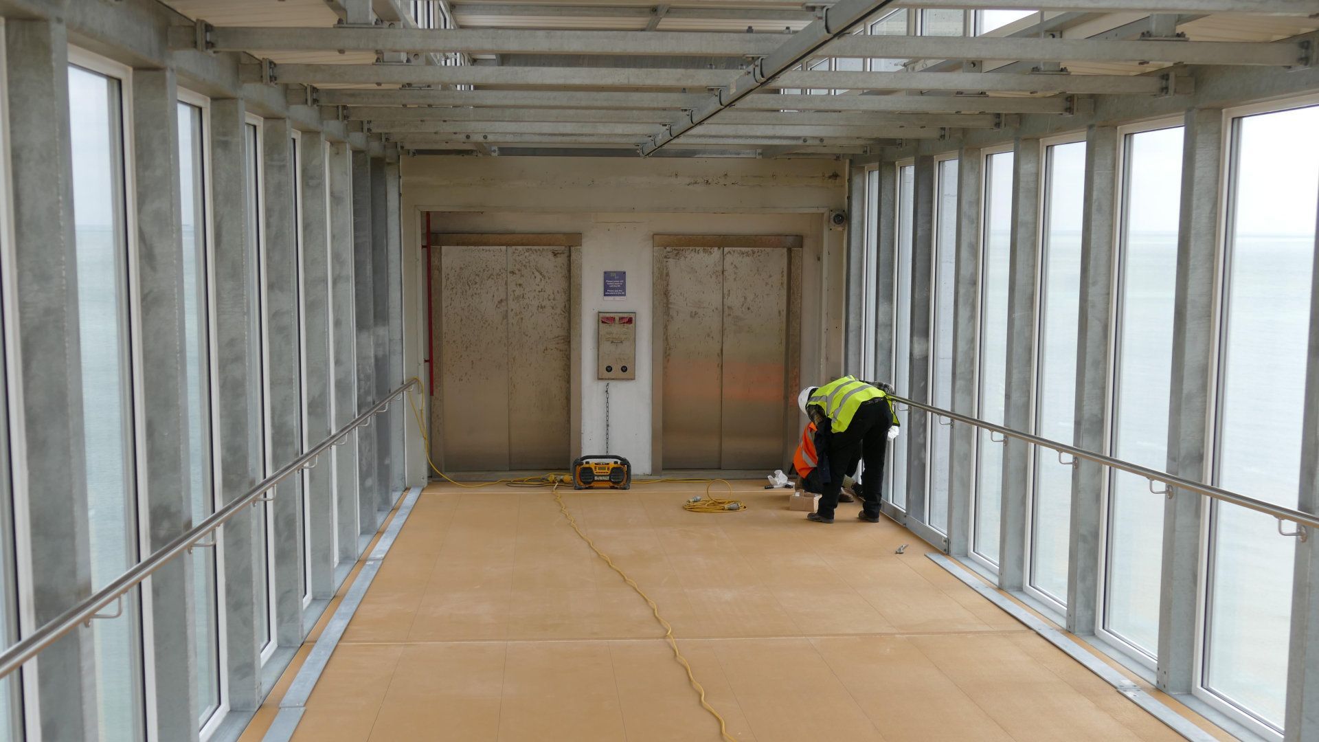 A man is working on the floor of a walkway.