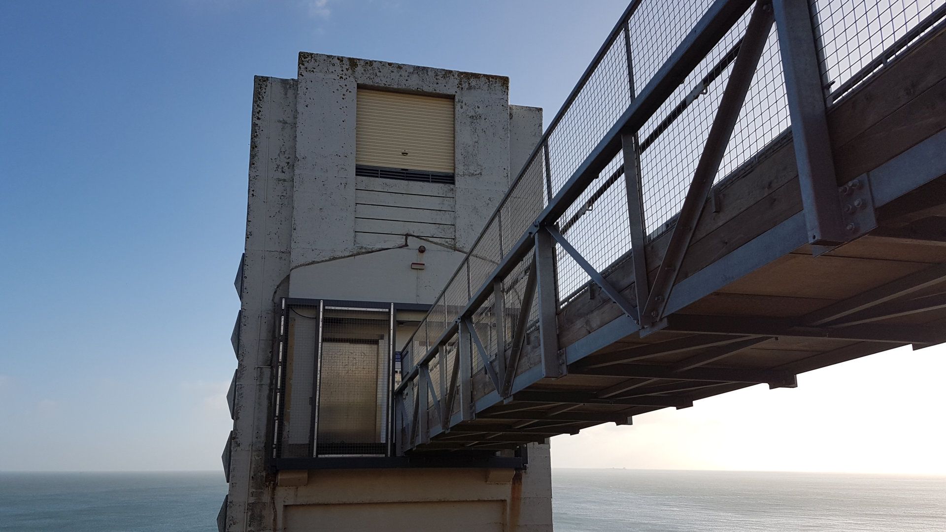 A bridge over a body of water with a building in the background