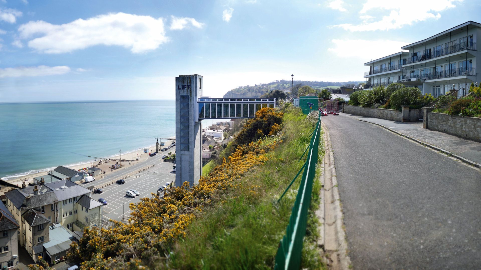 A road leading to the ocean with a building in the background