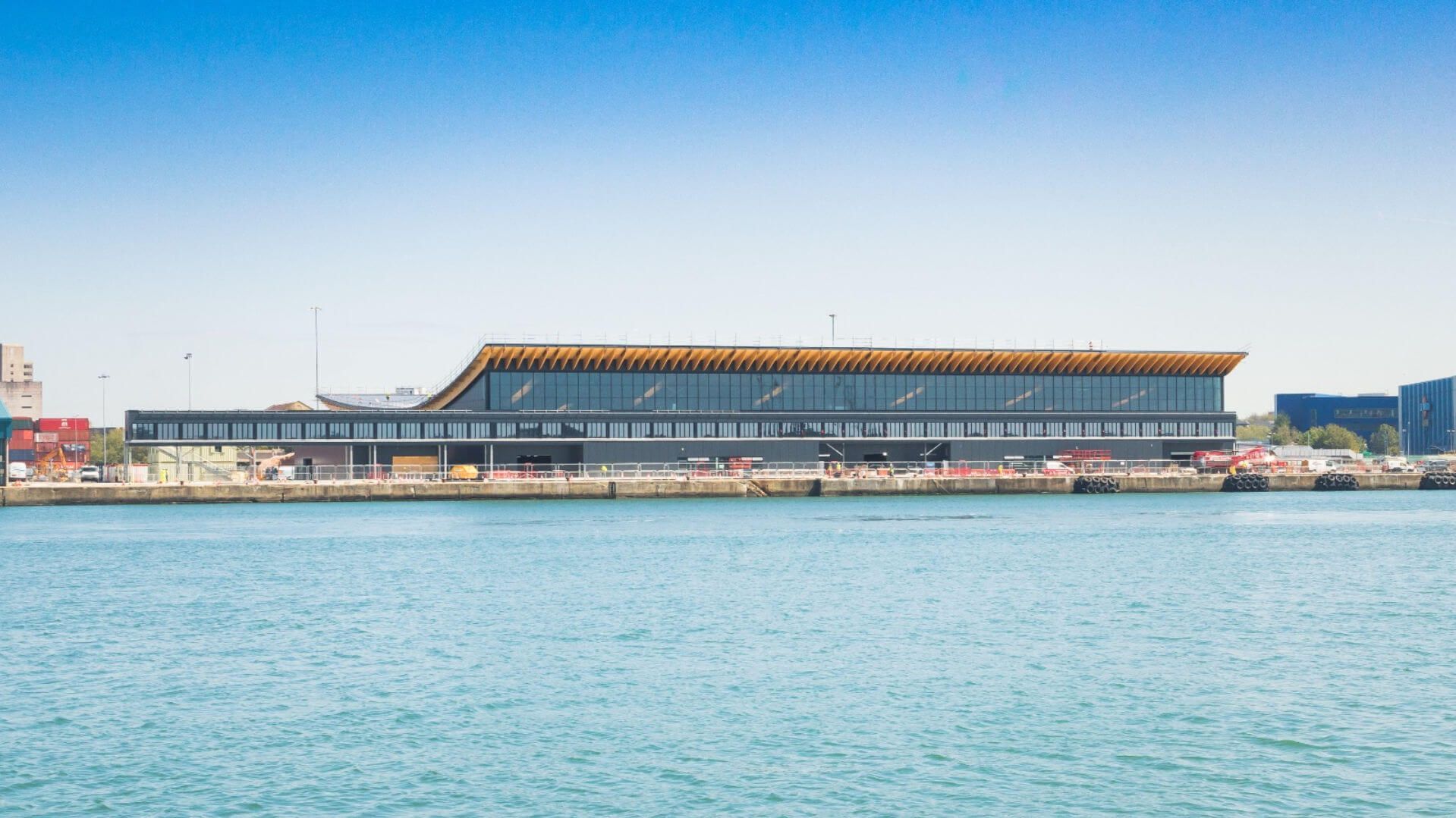 A large building is sitting next to a body of water.