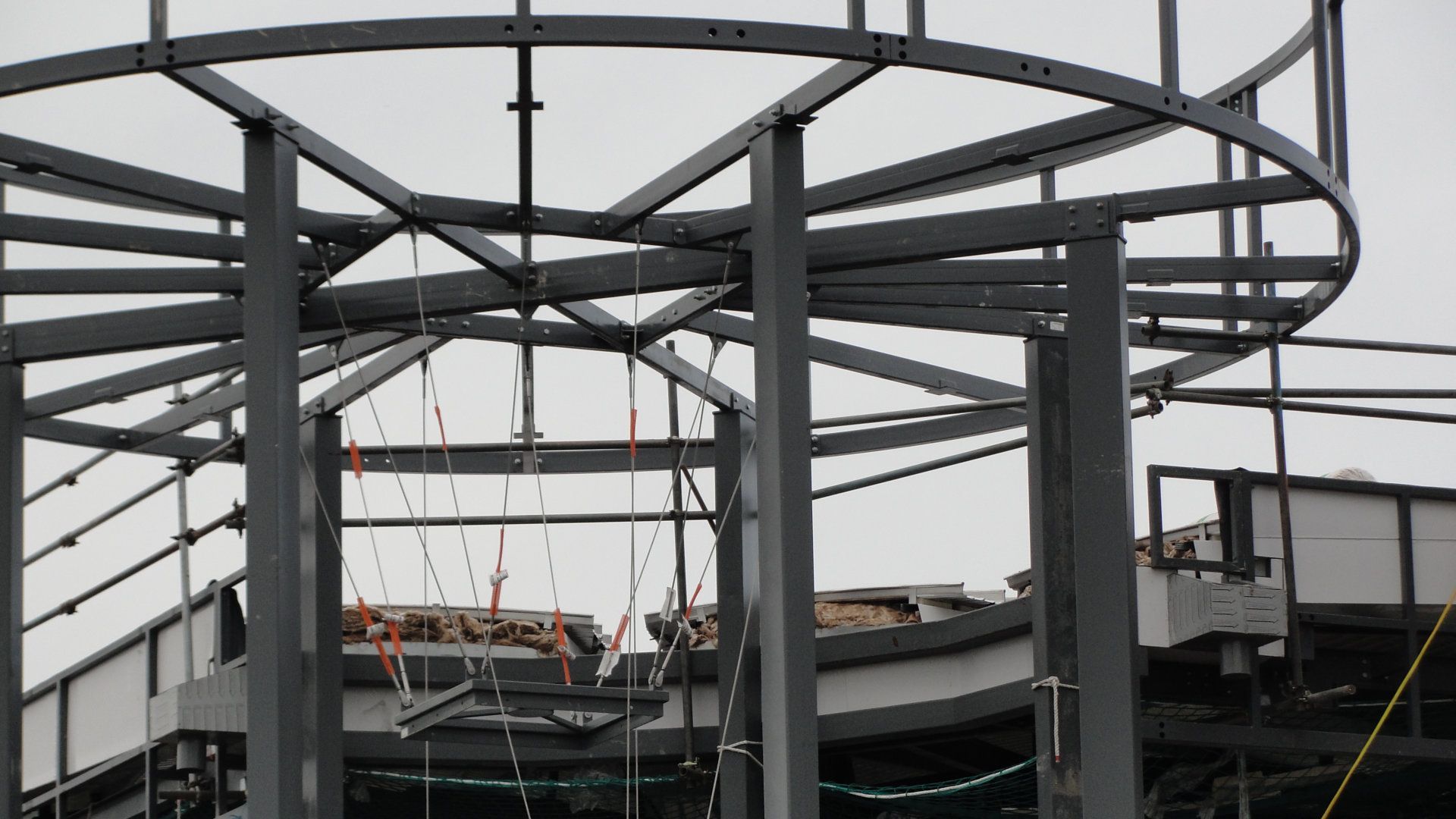 A large metal structure is being built on top of a building.