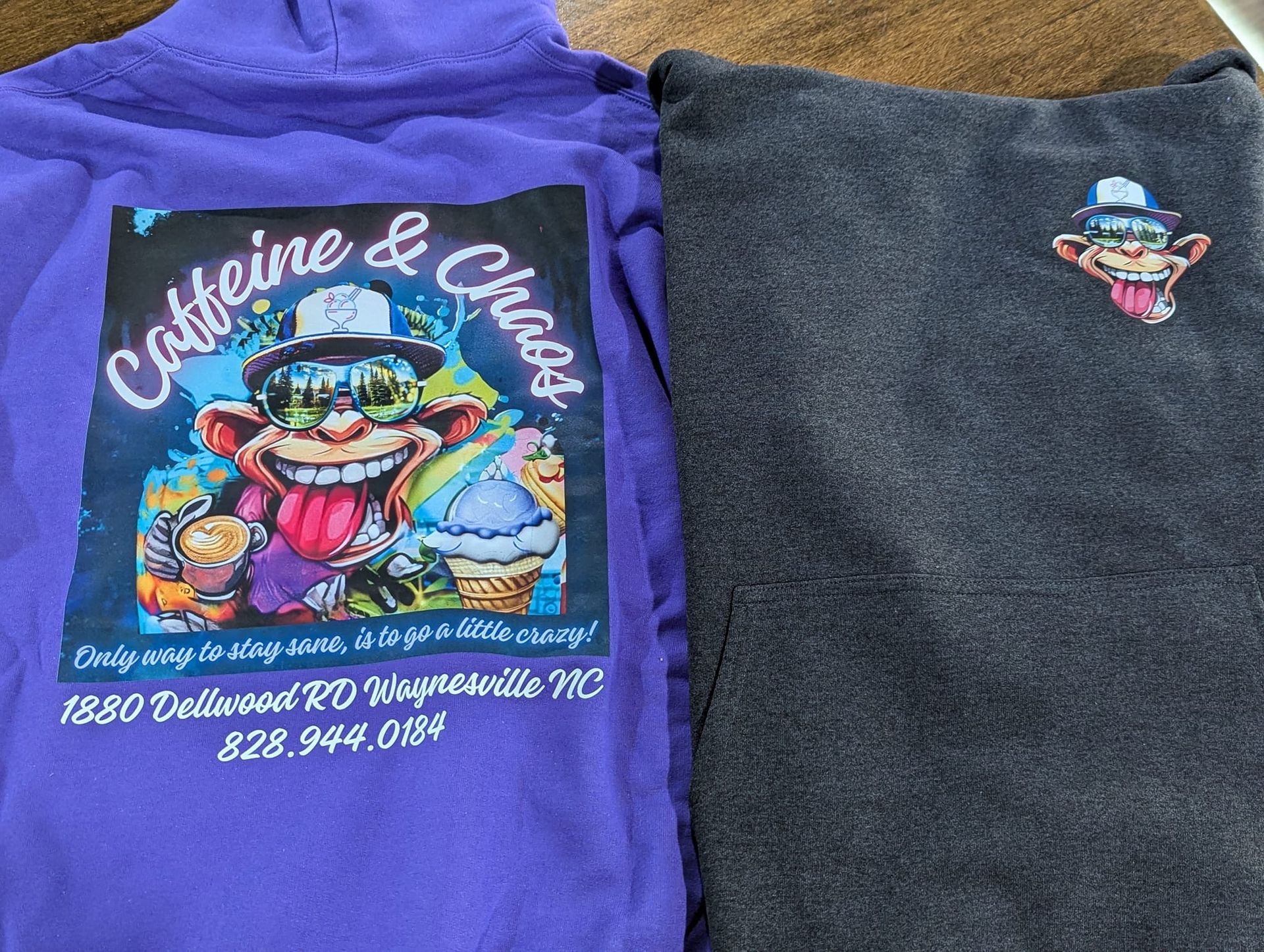 Two sweatshirts. Purple one has a cartoon graphic for 