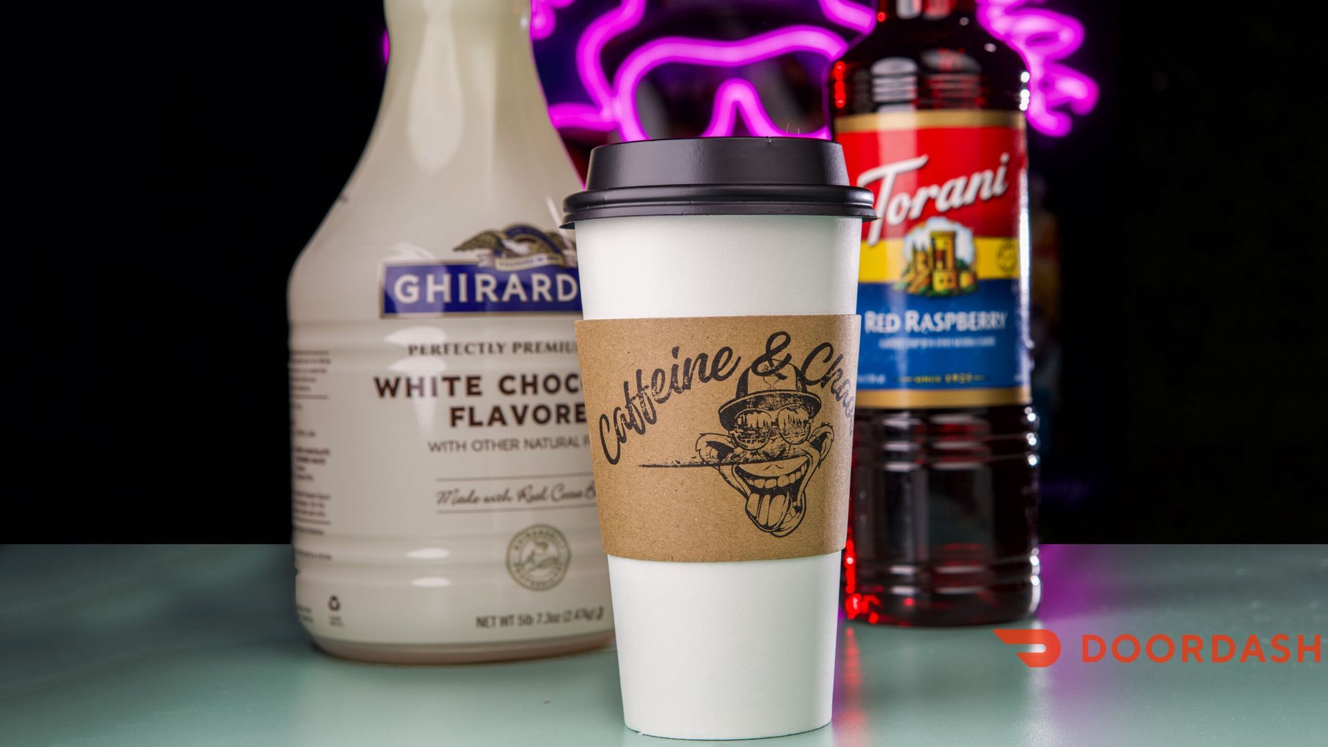 White coffee cup with sleeve, Ghirardelli white chocolate flavor, and Torani blue raspberry syrup.