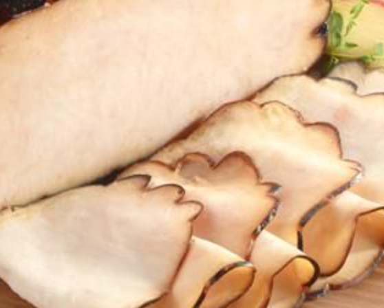 Sliced turkey meat with dark edges, light brown color.