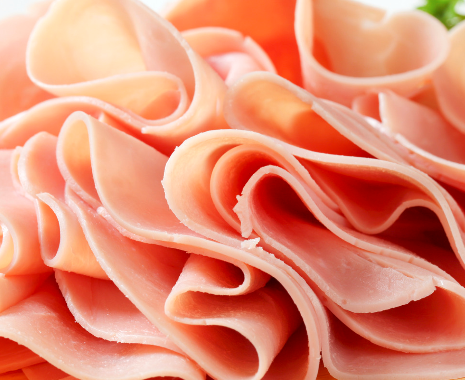 Thinly sliced pink ham, arranged in overlapping layers.