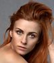 Woman with red hair, green eyes, looking at the viewer.