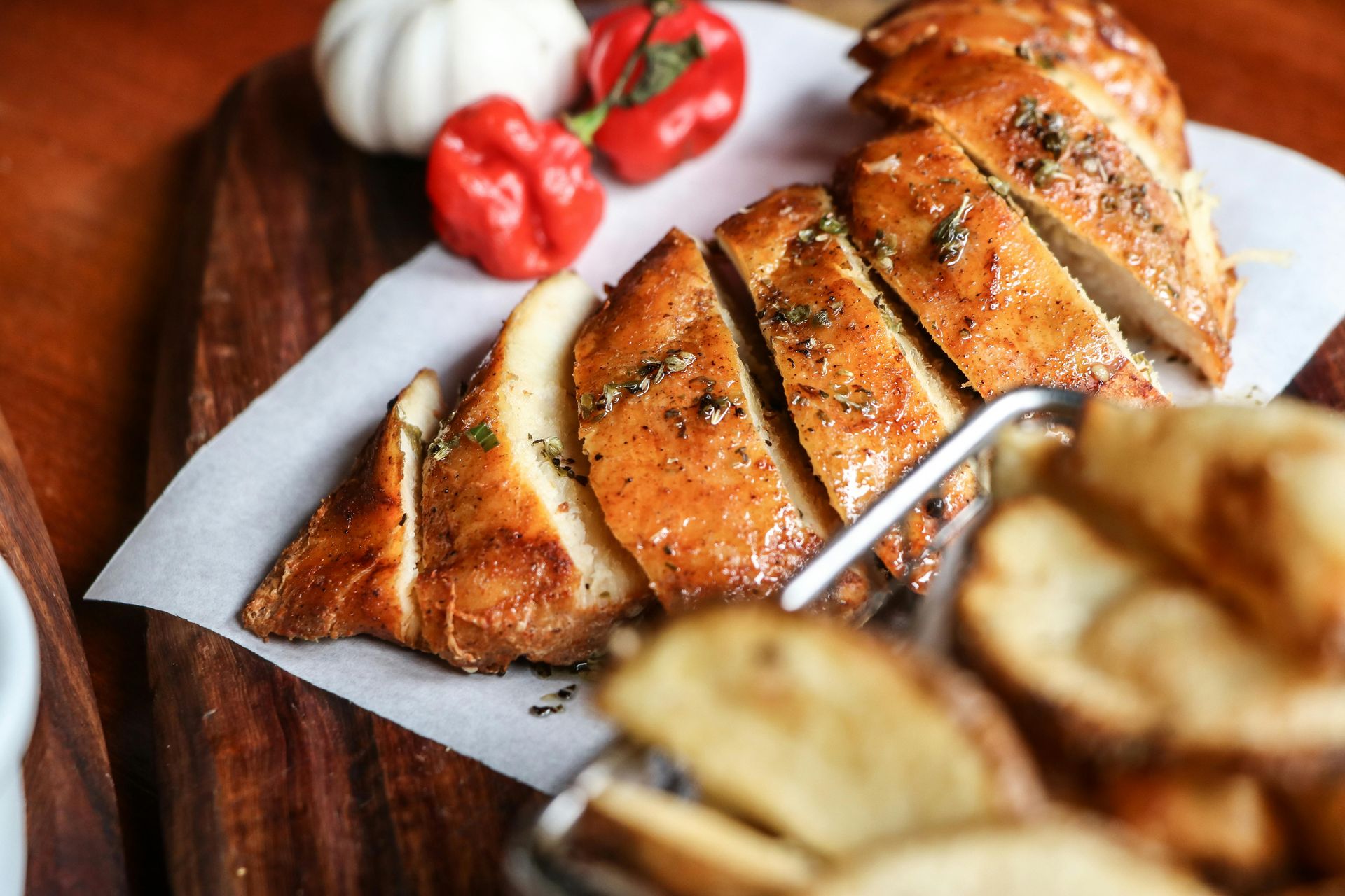 Loaf of crusty bread, one slice cut, on a wooden board.