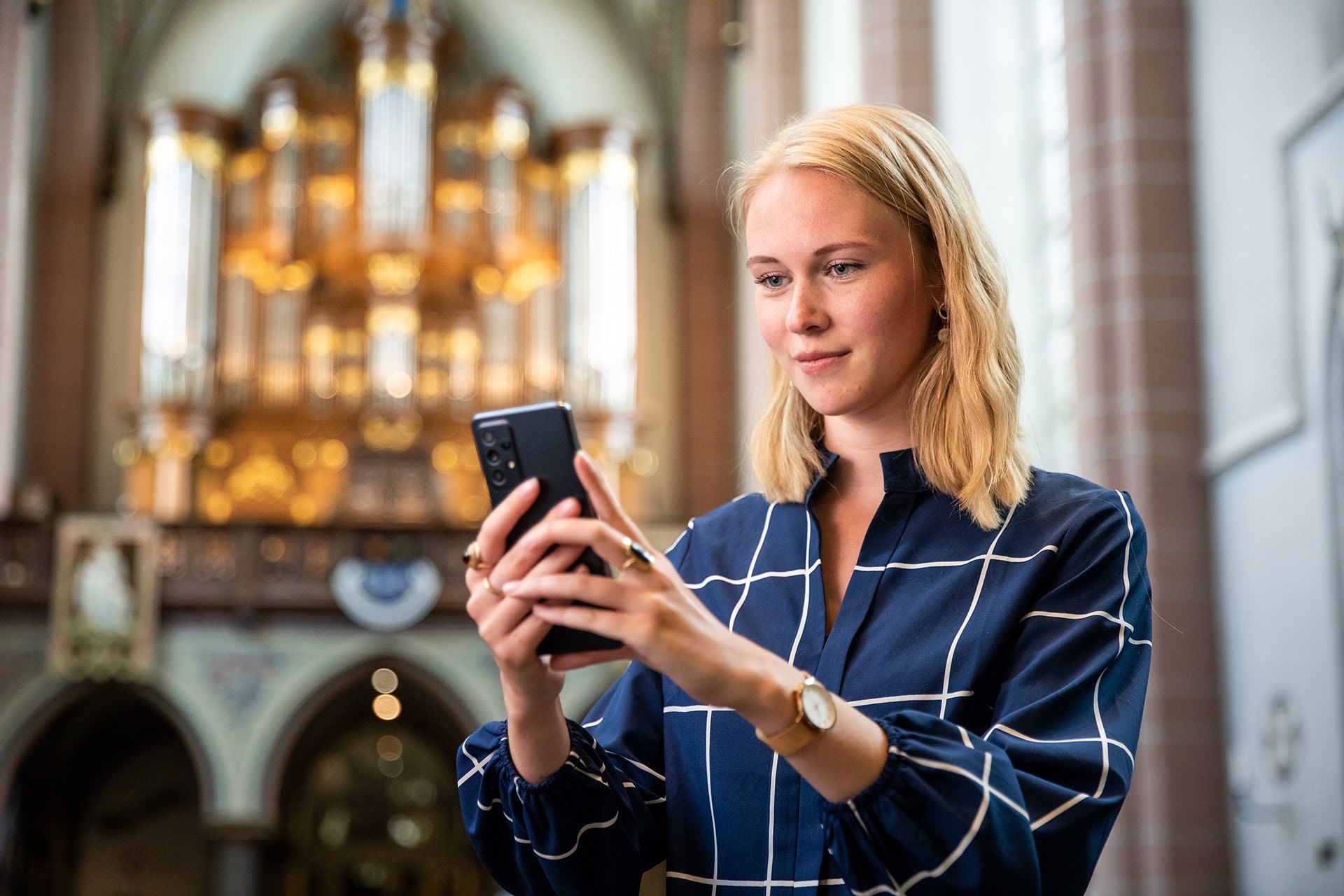 Meisje kijkt op haar telefoon in de kerk