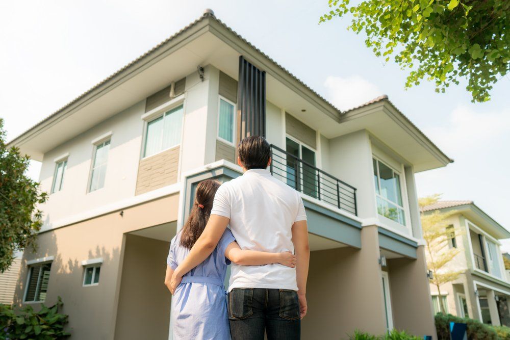 Couple Looking Happy In Front Of The House — Pre-Purchase Building Inspectors in East Ballina, NSW