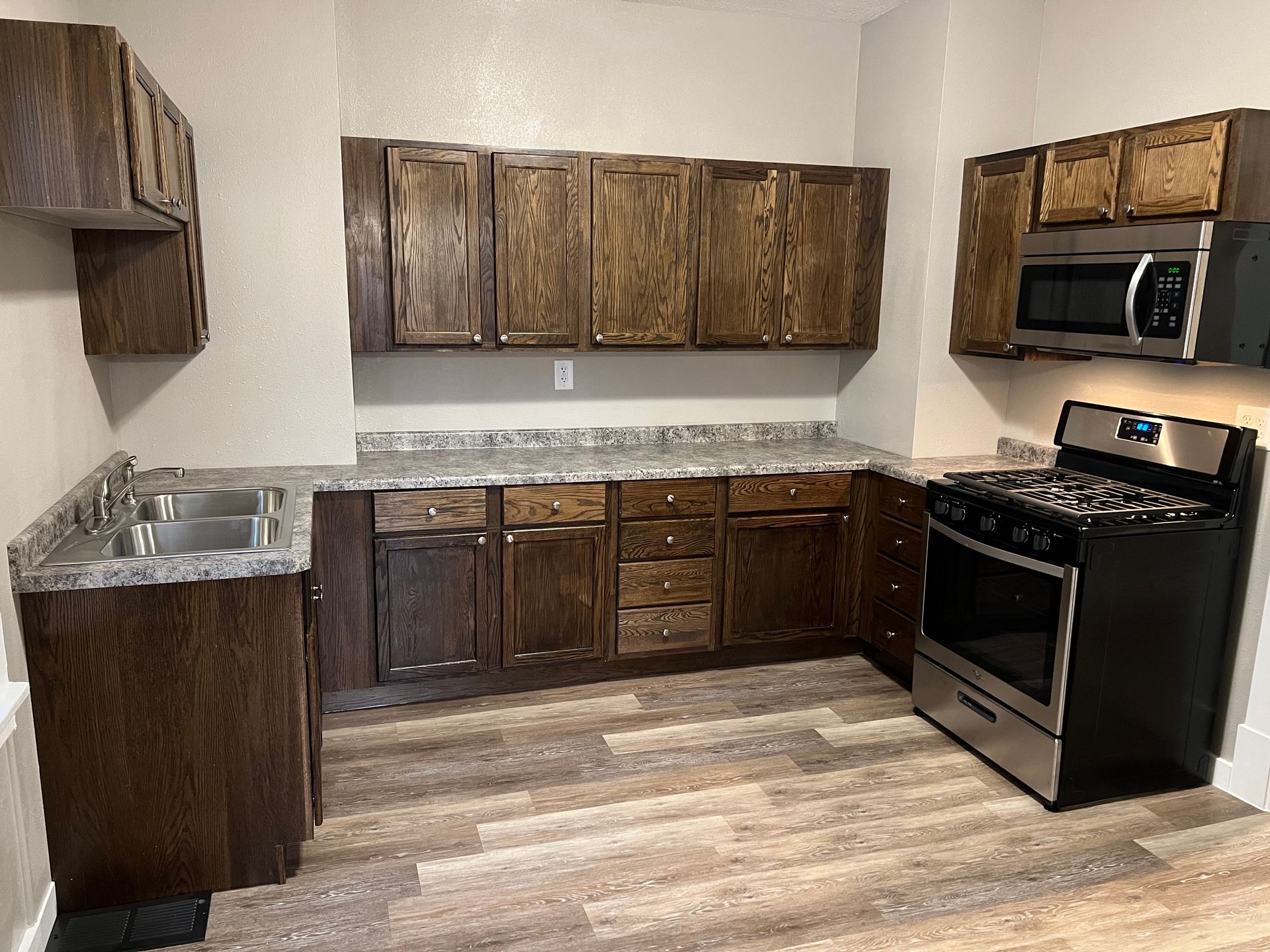A kitchen with stainless steel appliances and wooden cabinets.