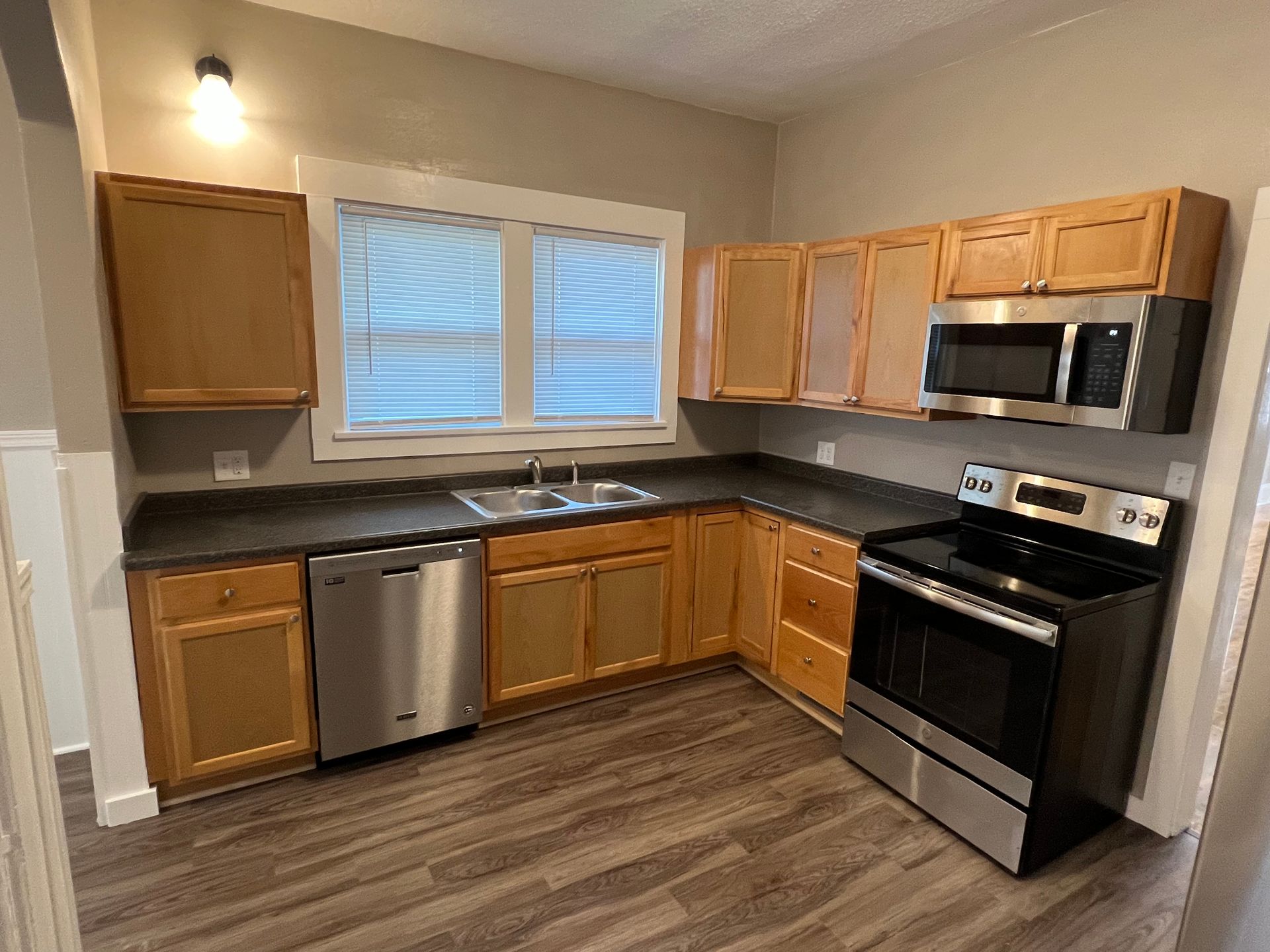 A kitchen with stainless steel appliances and wooden cabinets.