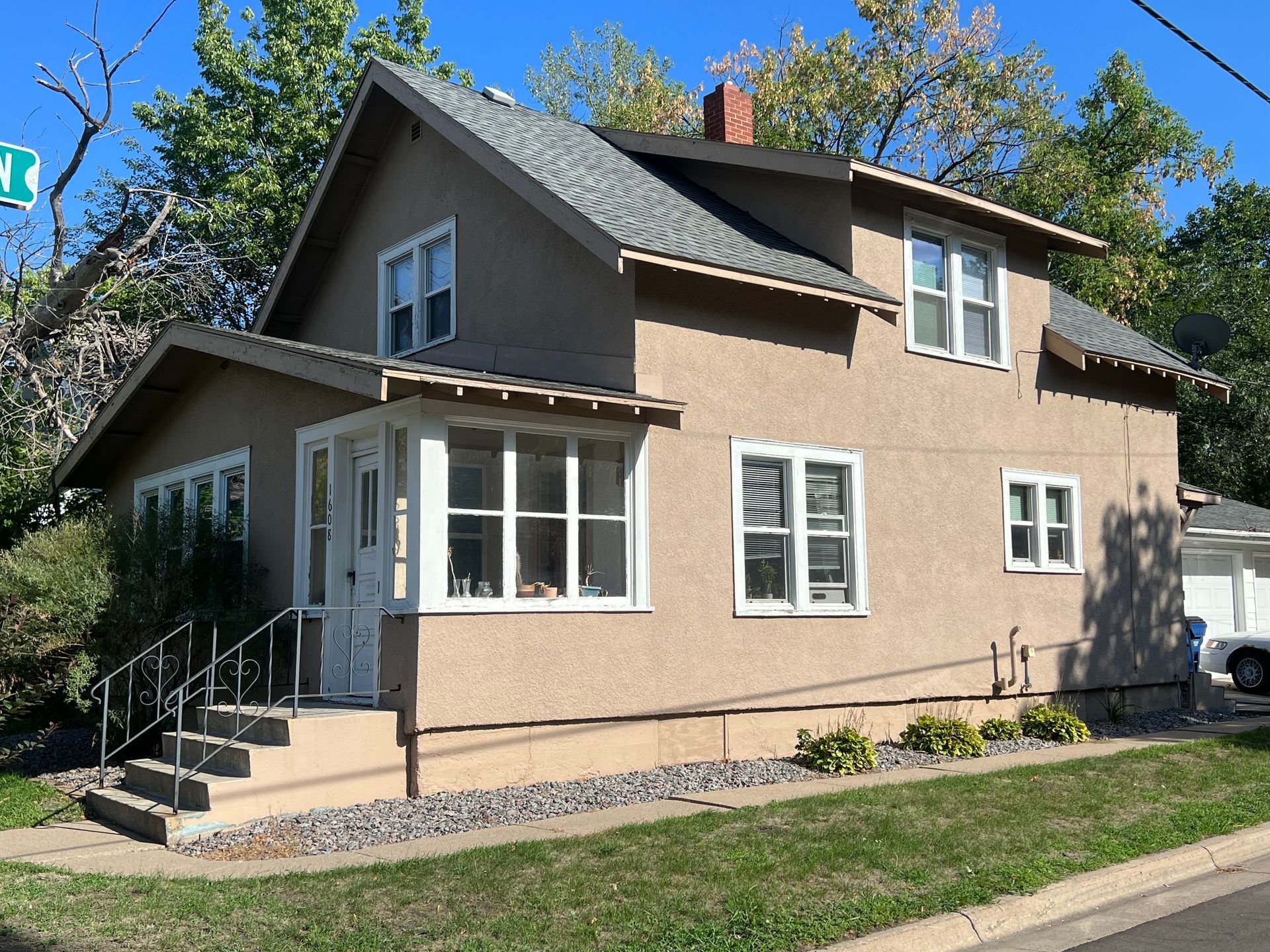 A brown house with white windows and a gray roof