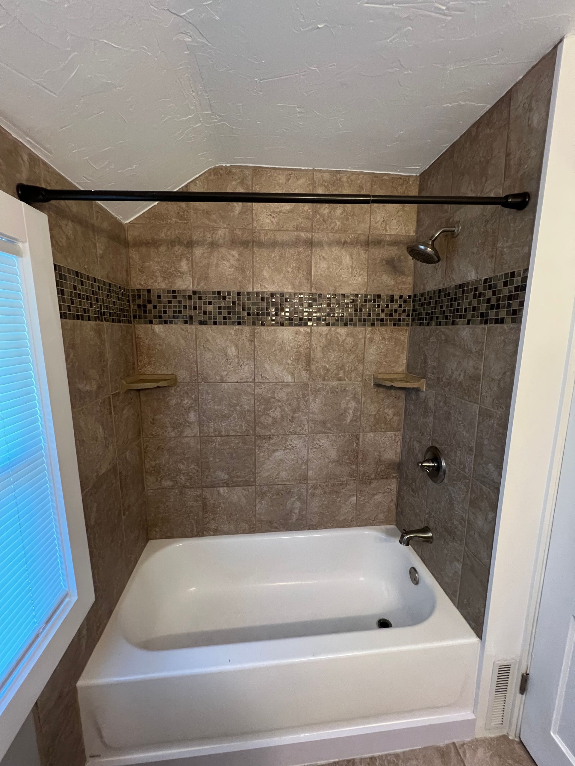 A bathroom with a bathtub and a shower.